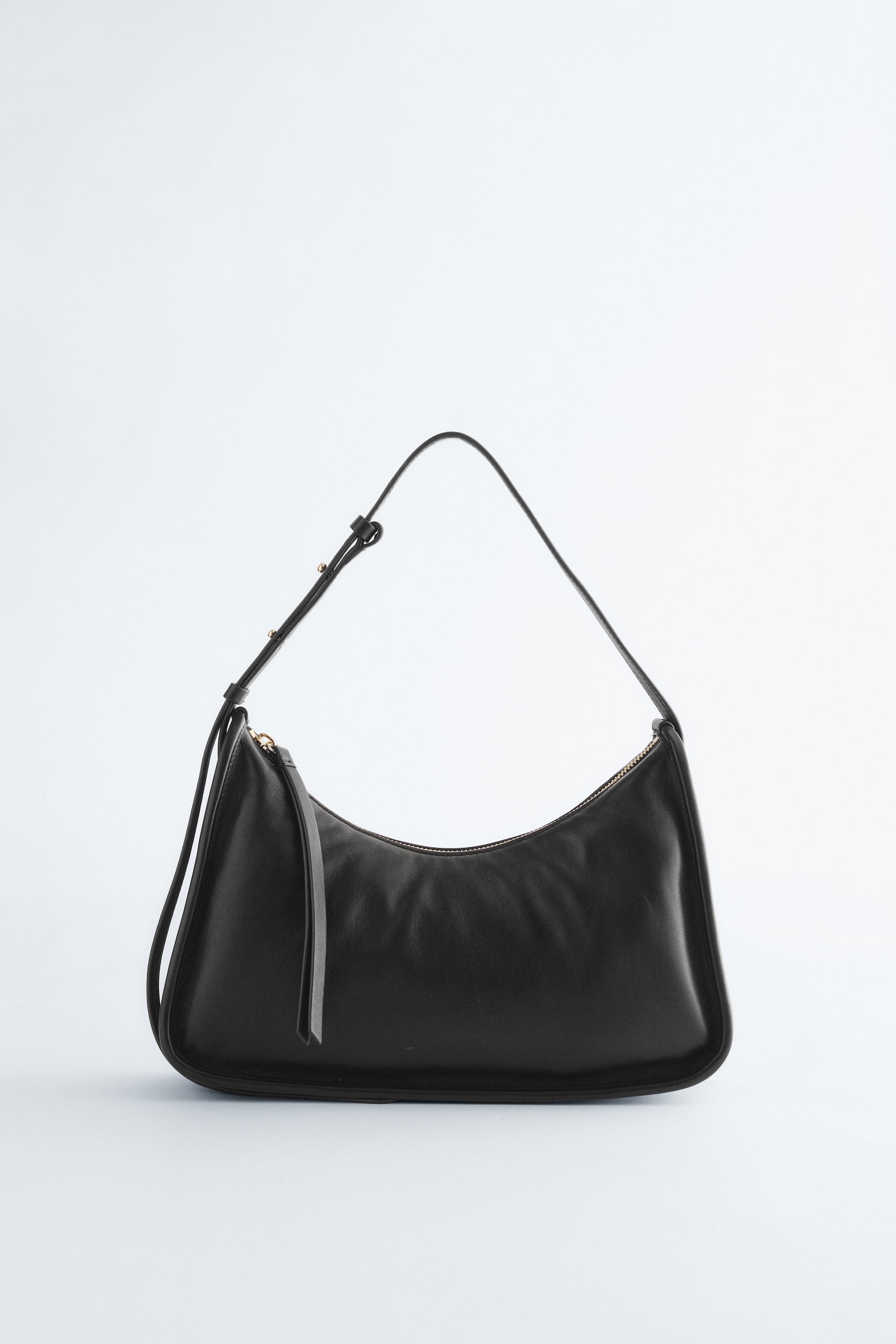 Ver imagen más grande: Un bolso hobo negro se presenta de FRENTE, con una silueta suave, ligeramente arrugada y en forma de media luna. Muestra una correa de hombro delgada y ajustable con herrajes en tono dorado y un cierre superior de cremallera con una lengüeta de tirador larga.