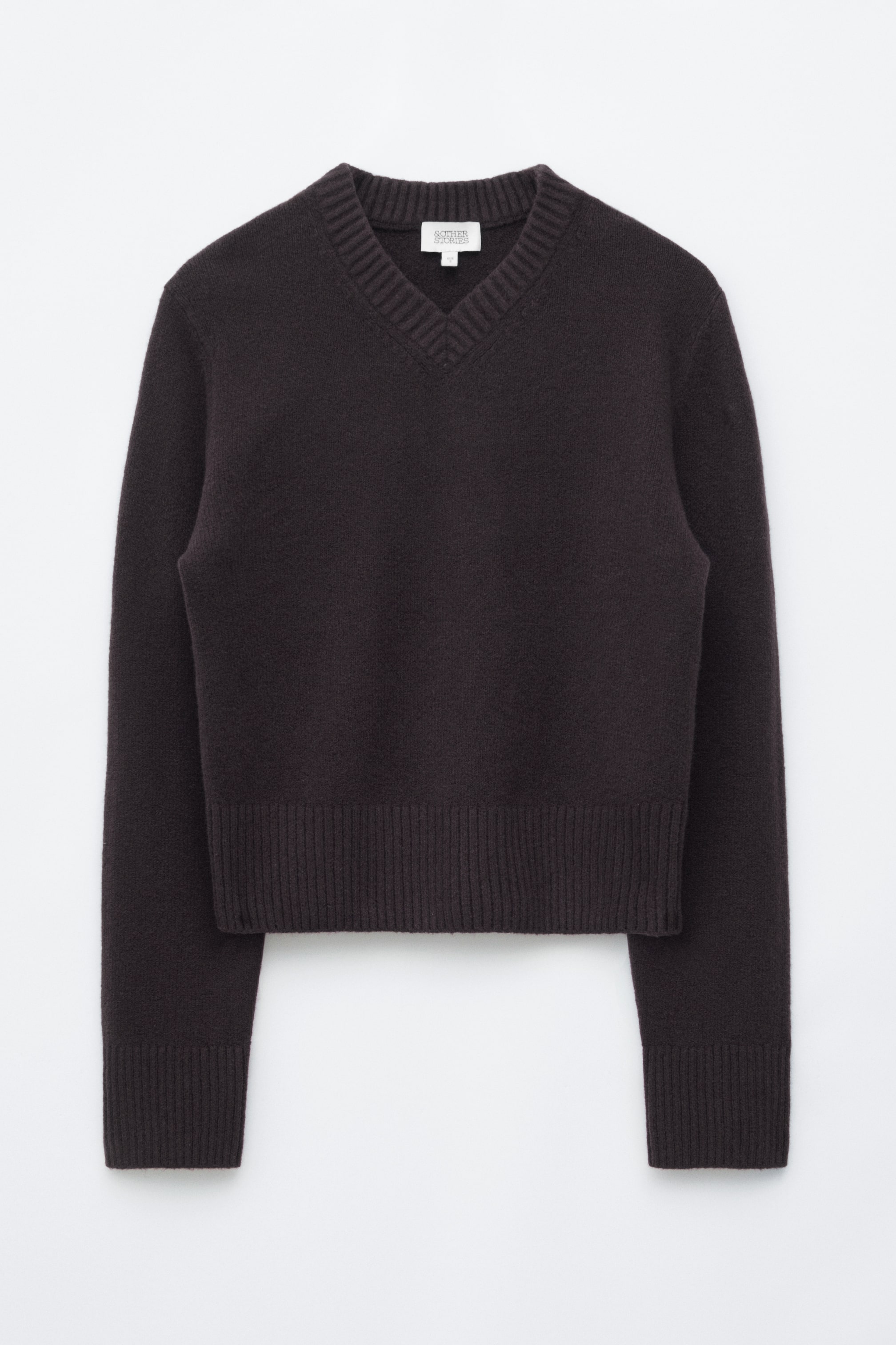 Agrandir l'image: Un pull en maille brun foncé est présenté de face, avec un col en V côtelé épais et une coupe régulière. Il présente un large ourlet côtelé et des poignets côtelés assortis sur les manches longues.