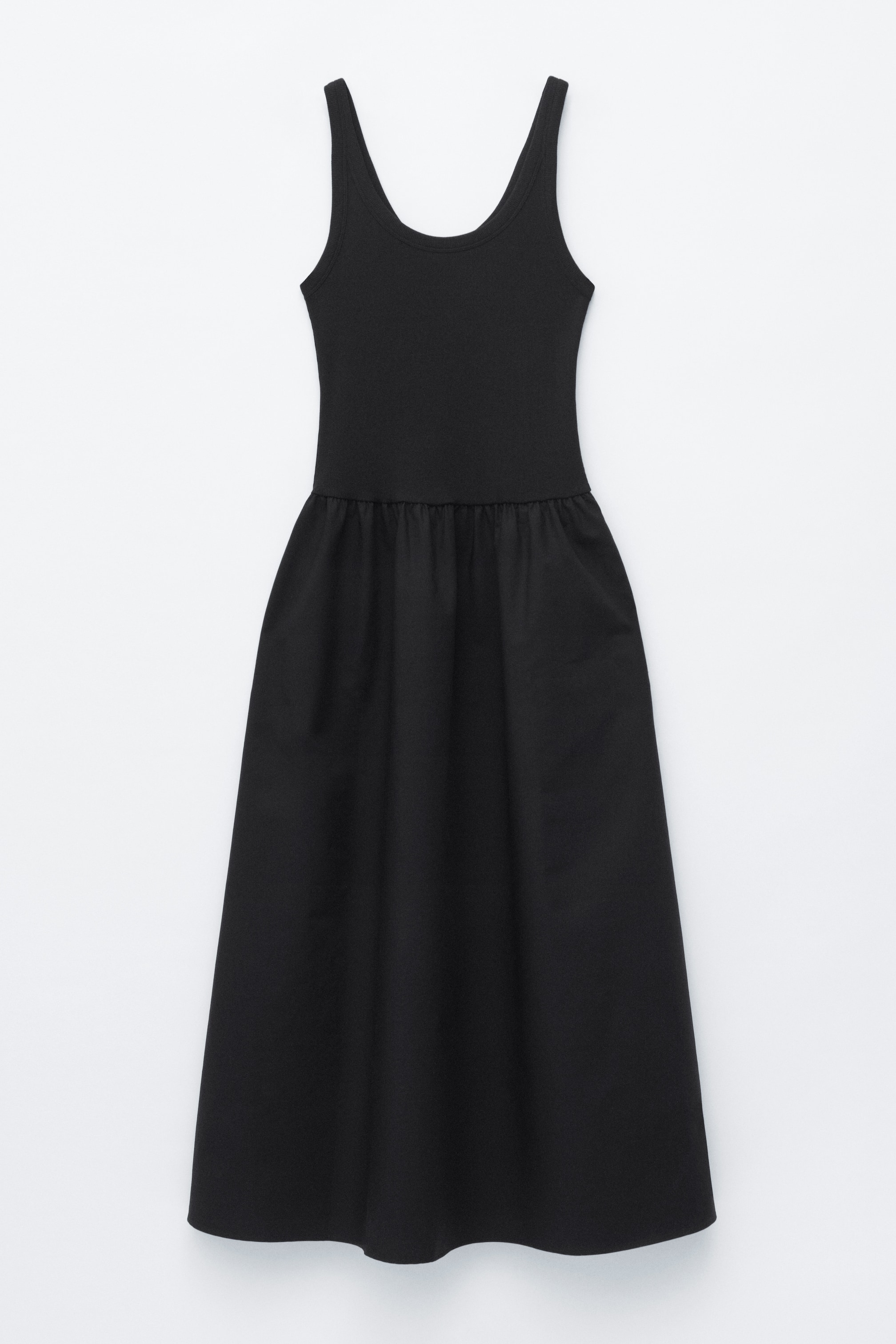 Visa större bild: Den svarta tankklänningen visas framifrån, med en ribbad livstycke som övergår i en rynkad A-linje kjol.