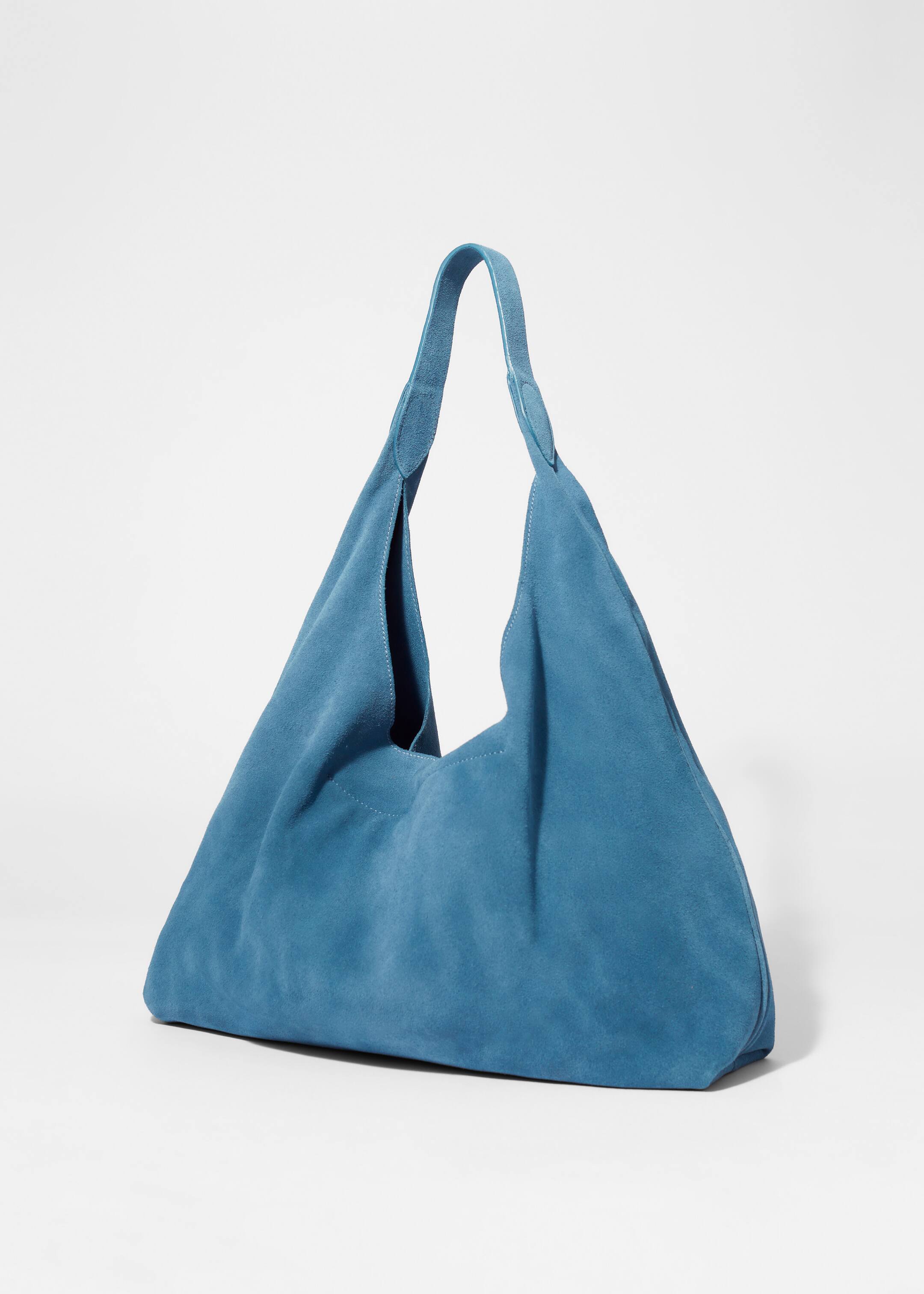 Visualizza immagine più grande: Una borsa tote blu, realizzata in morbida pelle scamosciata con finitura opaca, presenta una cucitura decorativa verticale lungo il centro frontale e un unico ampio manico a spalla attaccato con linguette in scamosciato coordinato.
