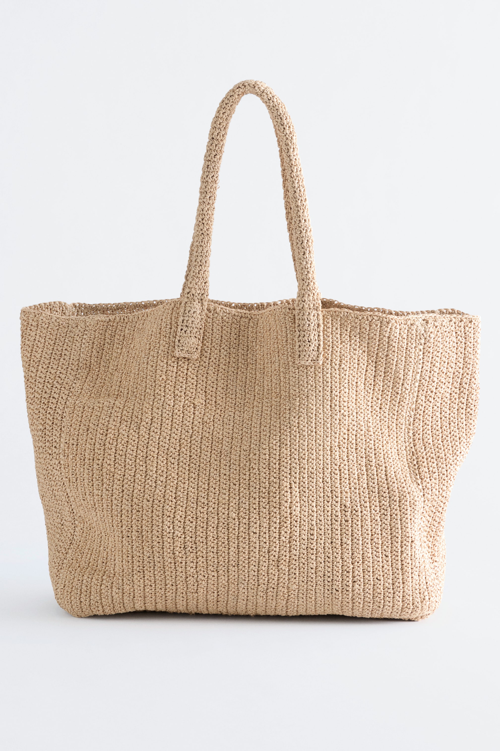 Se større billede: En lysebeige papirstrå taske vender fronten, med en afslappet form og to løkker til skulderstropper.