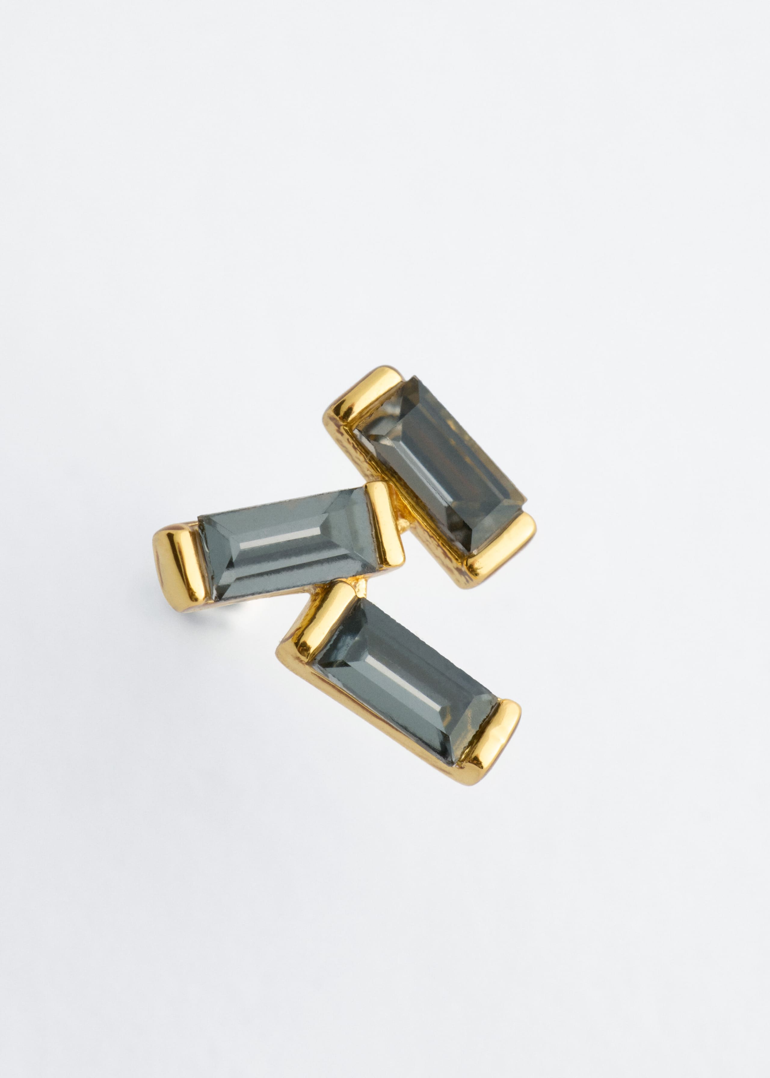 Dieser Ohrstecker aus Messing zeigt drei im Baguette-Schliff geschliffene, rauchgraue Steine, die in einer versetzten Cluster-Anordnung arrangiert sind. Der Ohrstecker ist frontal ausgerichtet und hebt die polierten, goldfarbenen Fassungen hervor, die jeden rechteckigen Stein sicher halten.