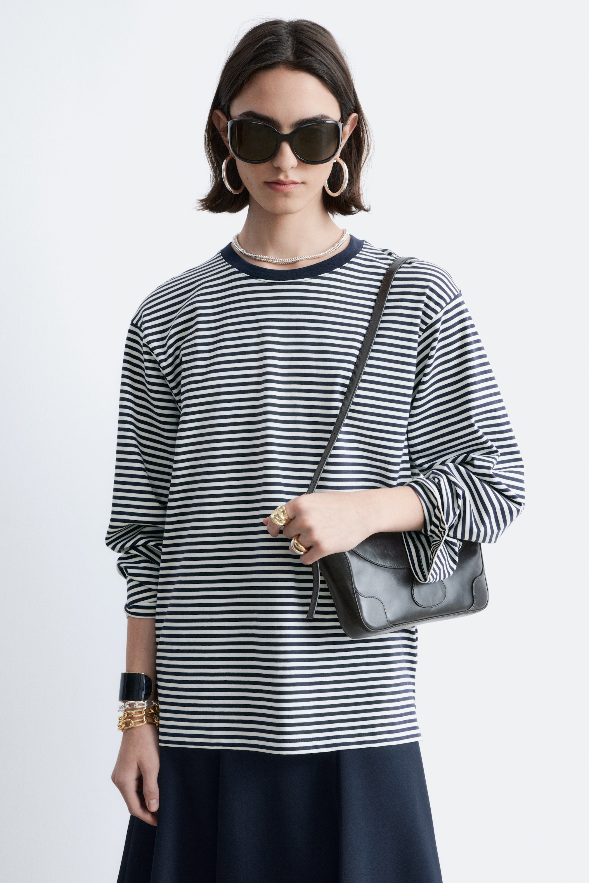 הצגת תמונה גדולה יותר: חולצה עם שרוולים ארוכים מציגה פסים אופקיים בכחול נייבי ולבן, עם צווארון עגול עם גימור כחול נייבי אחיד, ושרוולים ארוכים.