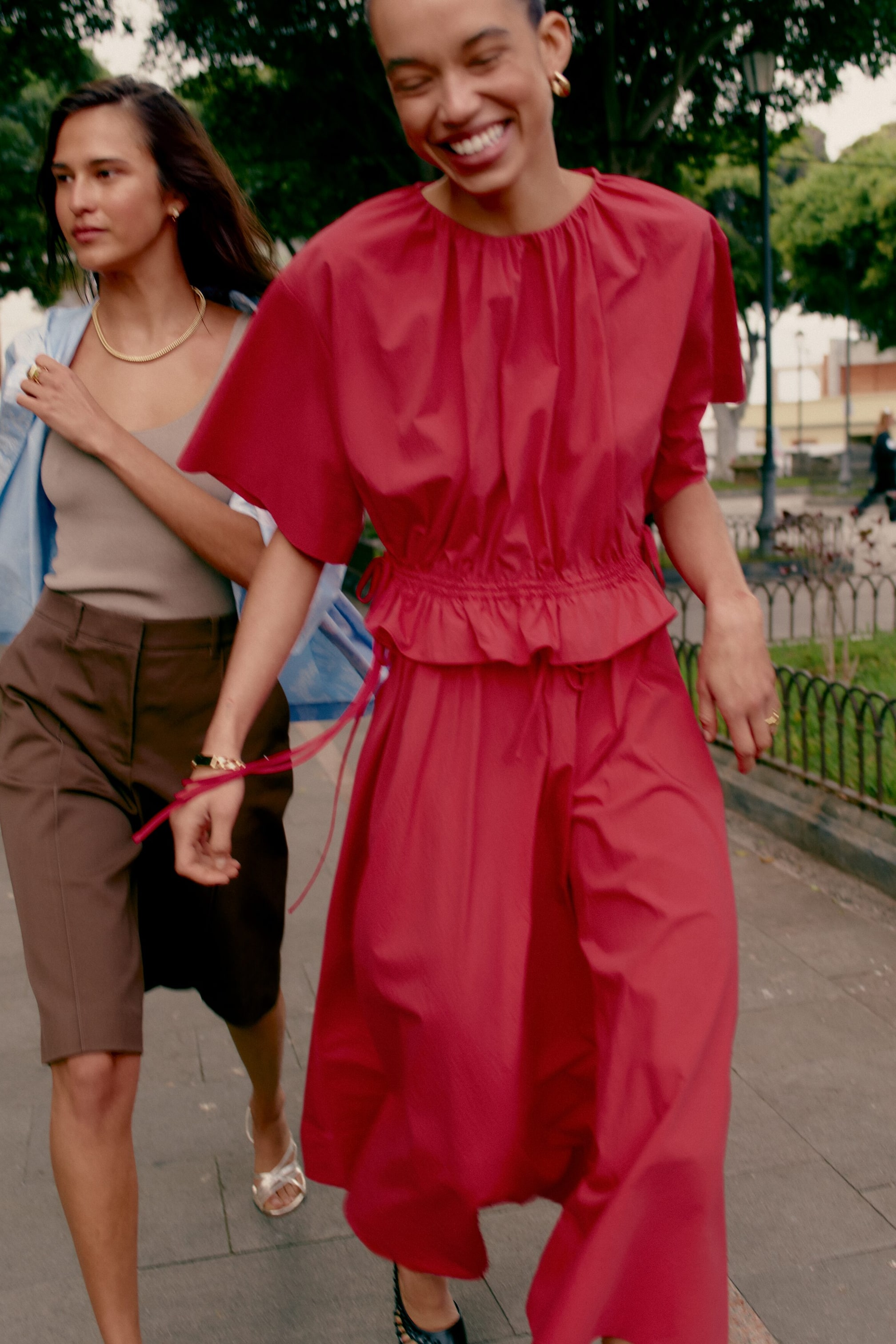 Visualizza l'immagine ingrandita: Un abito midi rosso presenta uno scollo rotondo arricciato e maniche corte e ampie. Un punto vita elasticizzato con coulisse laterali visibili crea un dettaglio a volant sopra una gonna piena e fluente.