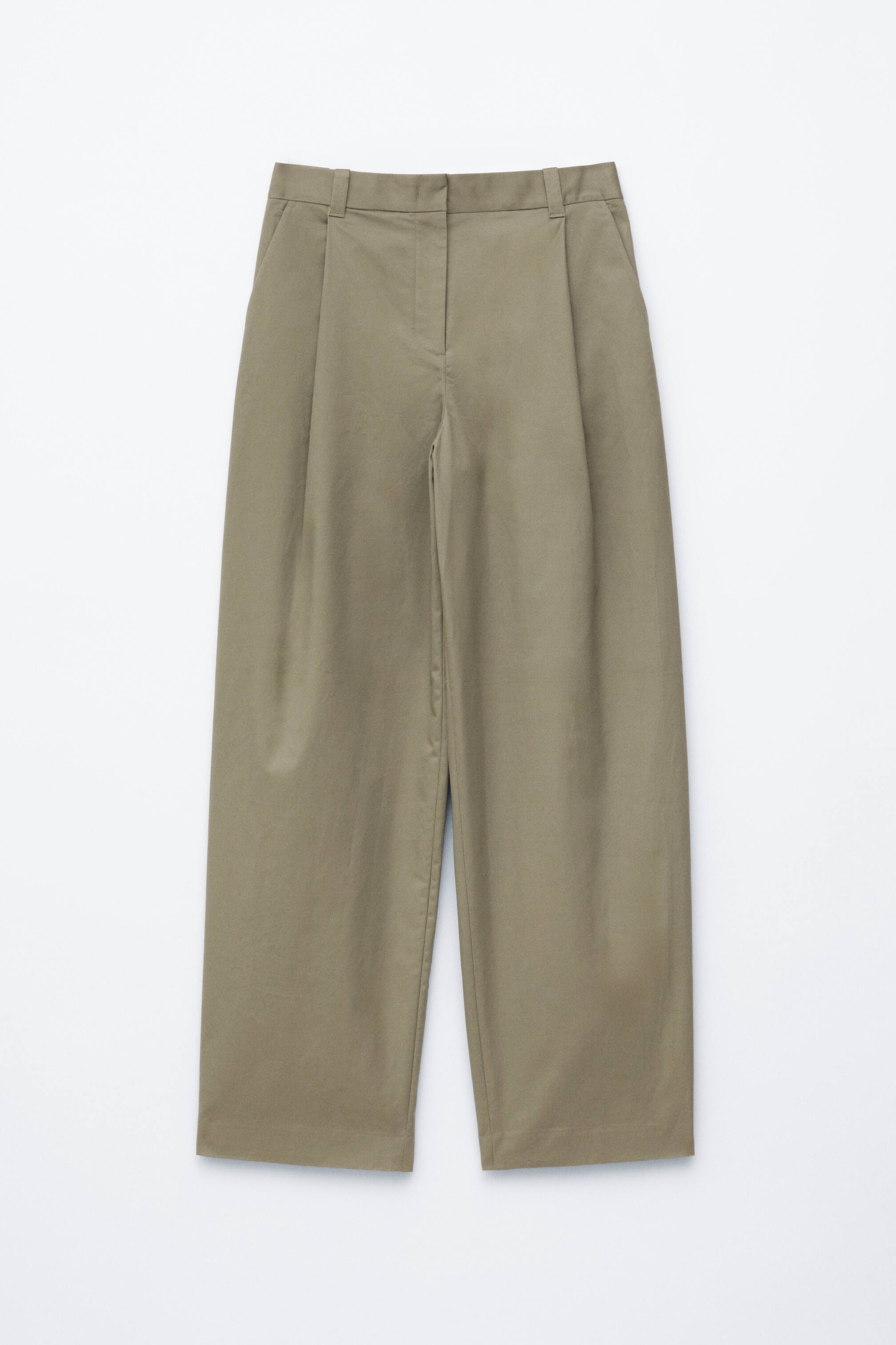 Ver imagem maior: Um par de calças largas em caqui está a ser apresentado de frente. Apresenta uma cintura plana com presilhas para cinto e um fecho frontal oculto. Pregas simples detalham a frente de cada perna, e bolsos laterais aparecem nas ancas, com as pernas largas caindo até uma bainha reta.