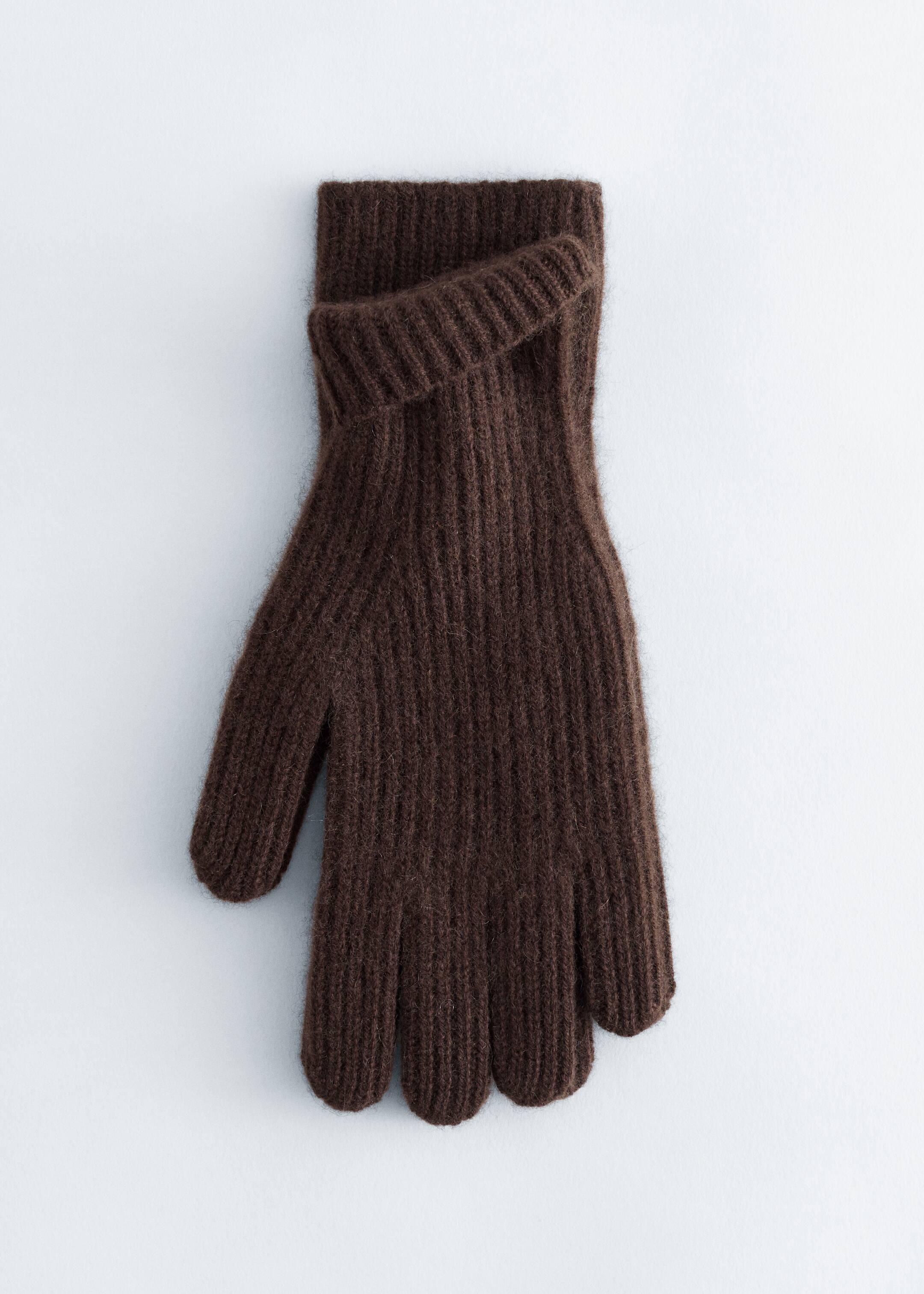 Größeres Bild ansehen: Ein dunkelbrauner Handschuh liegt flach und zeigt seine gestrickte Konstruktion. Er weist markante vertikale Rippen über den gesamten Körper und die Finger auf, wobei das Bündchen ordentlich umgeschlagen ist, um eine deutlich gerippte Kante zu zeigen.