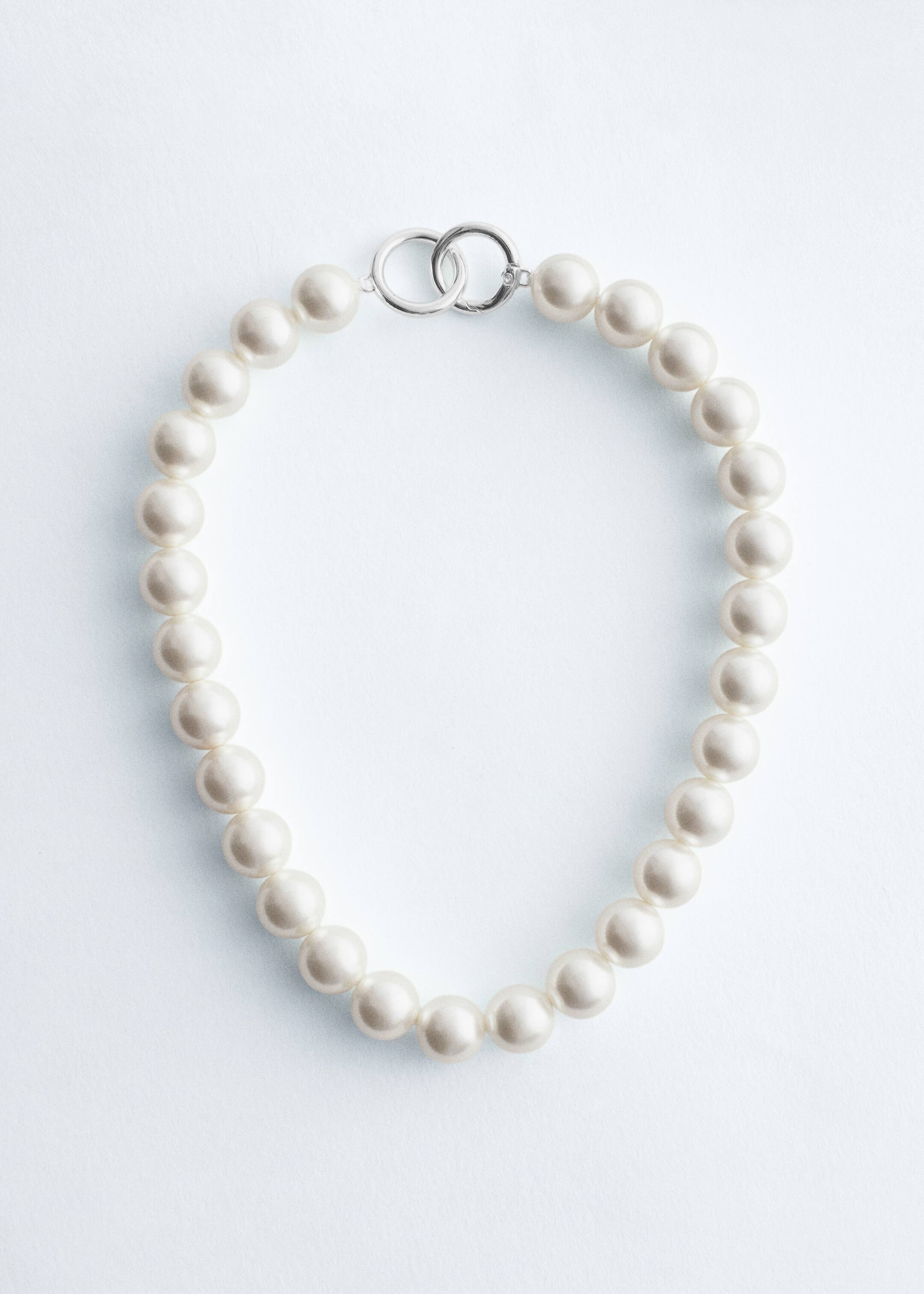 Visa större bild: Ett kort halsband är format av en sträng av överdimensionerade glaspärlor med en diameter på 1,4 cm och en pärlemorskimrande finish. Det är säkrat med två sammankopplade, polerade silverfärgade ringar, varav en är gångjärnsförsedd.
