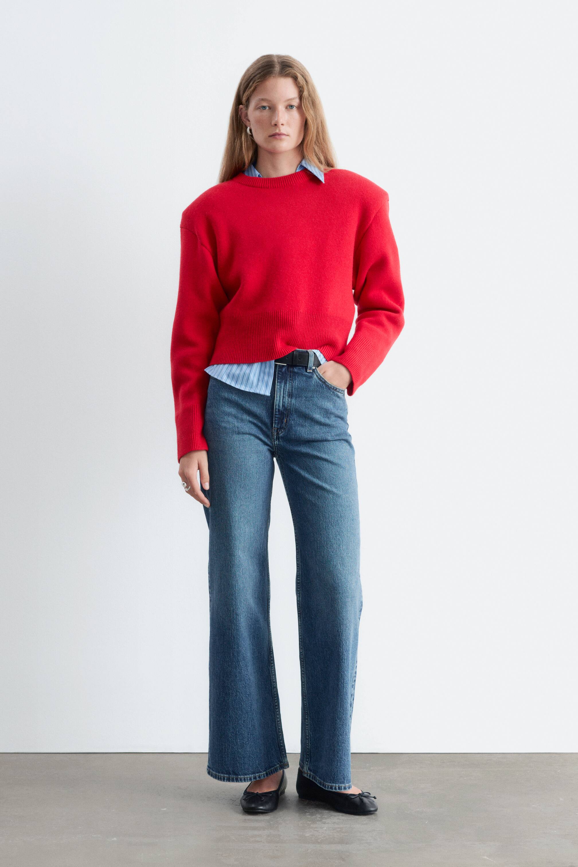 Größeres Bild ansehen: Diese hoch taillierten, weit geschnittenen blauen Denim-Jeans werden in einer Frontansicht gezeigt und verfügen über das klassische Five-Pocket-Design. Sie sitzen hoch in der Taille, sind mit einem schwarzen Gürtel gestylt und fallen in einer entspannten, geraden Silhouette.