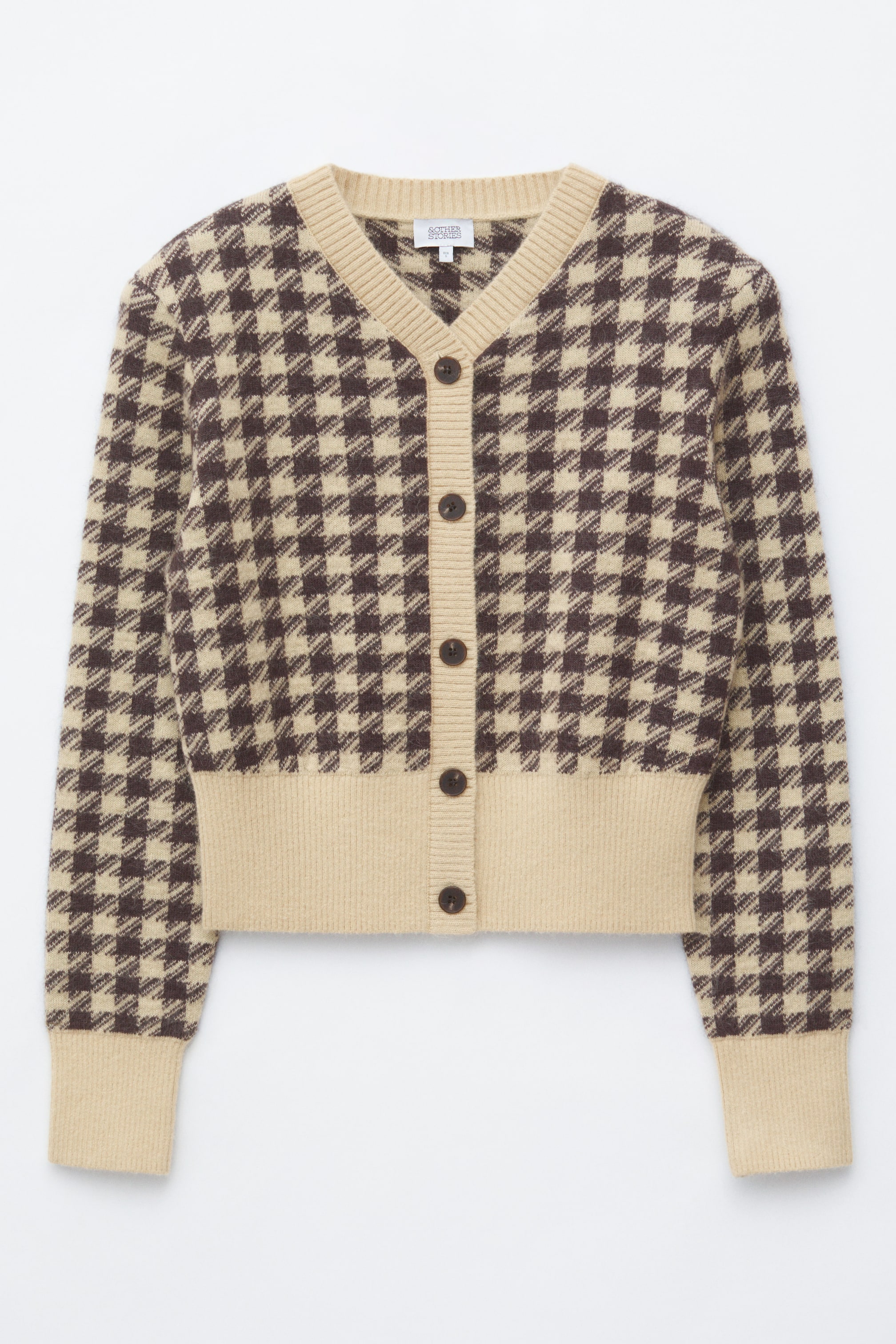Agrandir l'image: Un cardigan à motif pied-de-poule marron et beige présente un col en V et une fermeture boutonnée sur le devant. Il affiche six boutons marron foncé ainsi que des finitions côtelées beige le long du col en V, de la patte de boutonnage, des poignets et de l’ourlet.