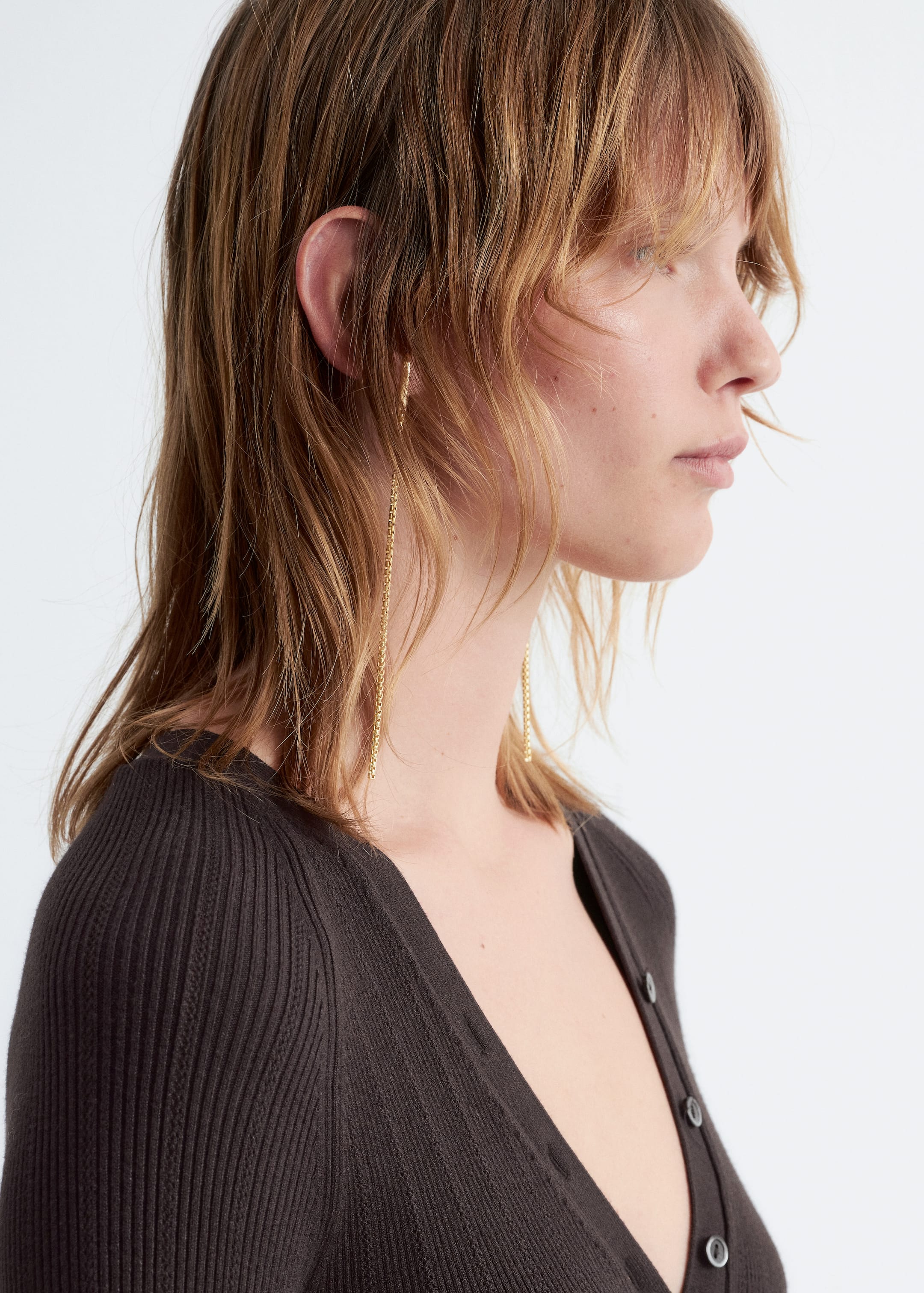 Visualizza immagine più grande: La modella indossa un body a coste slim-fit color carbone con scollo a V tracciato da bottoni e maniche lunghe taglio raglan.
