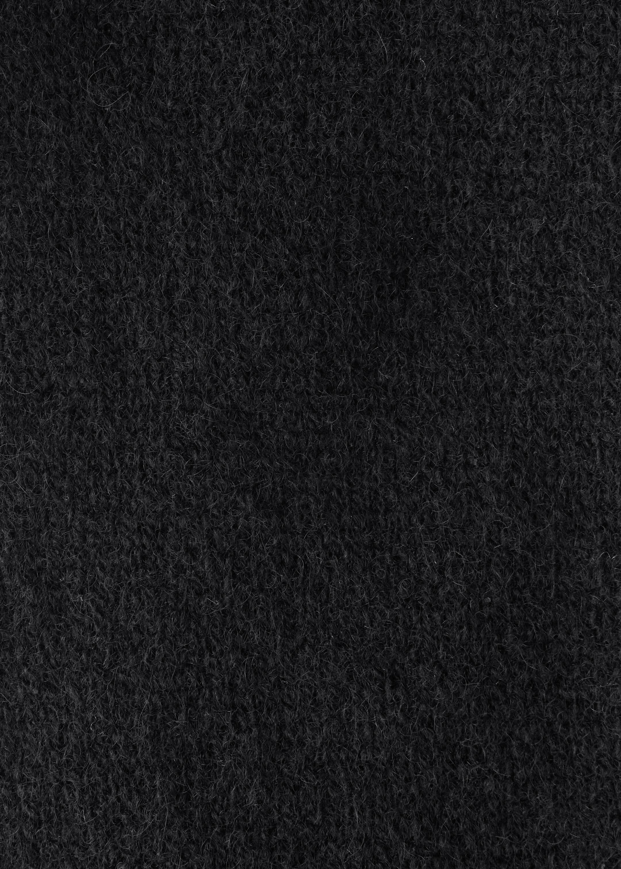 Ver imagem maior: A bandolete de caxemira está a exibir um close-up da sua textura escura, suave e fibrosa.