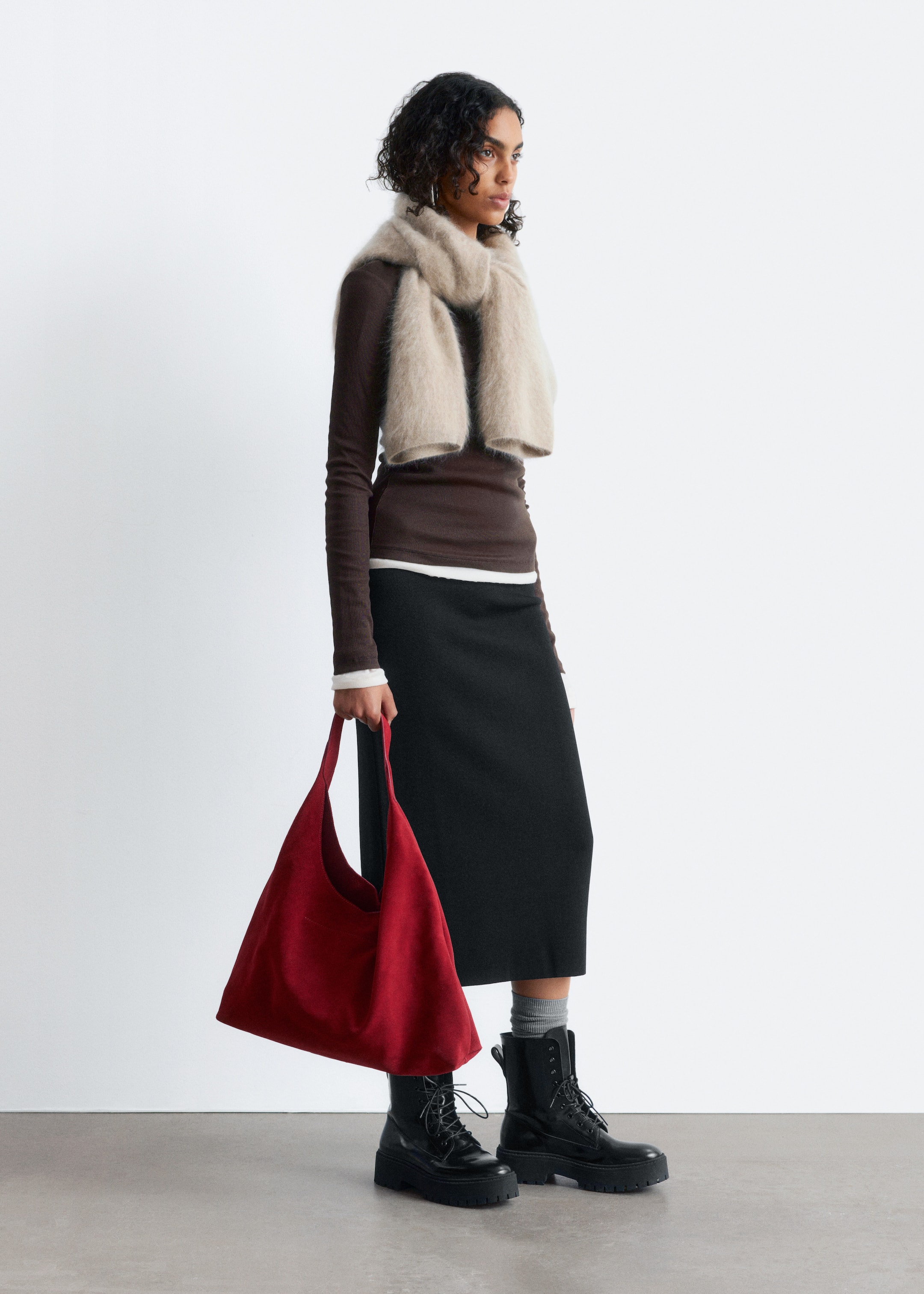 Visa större bild: En fluffig beige halsduk är draperad runt halsen, med sina ändar hängandes ner på framsidan, vilket visar upp dess voluminösa form och mjuka textur.