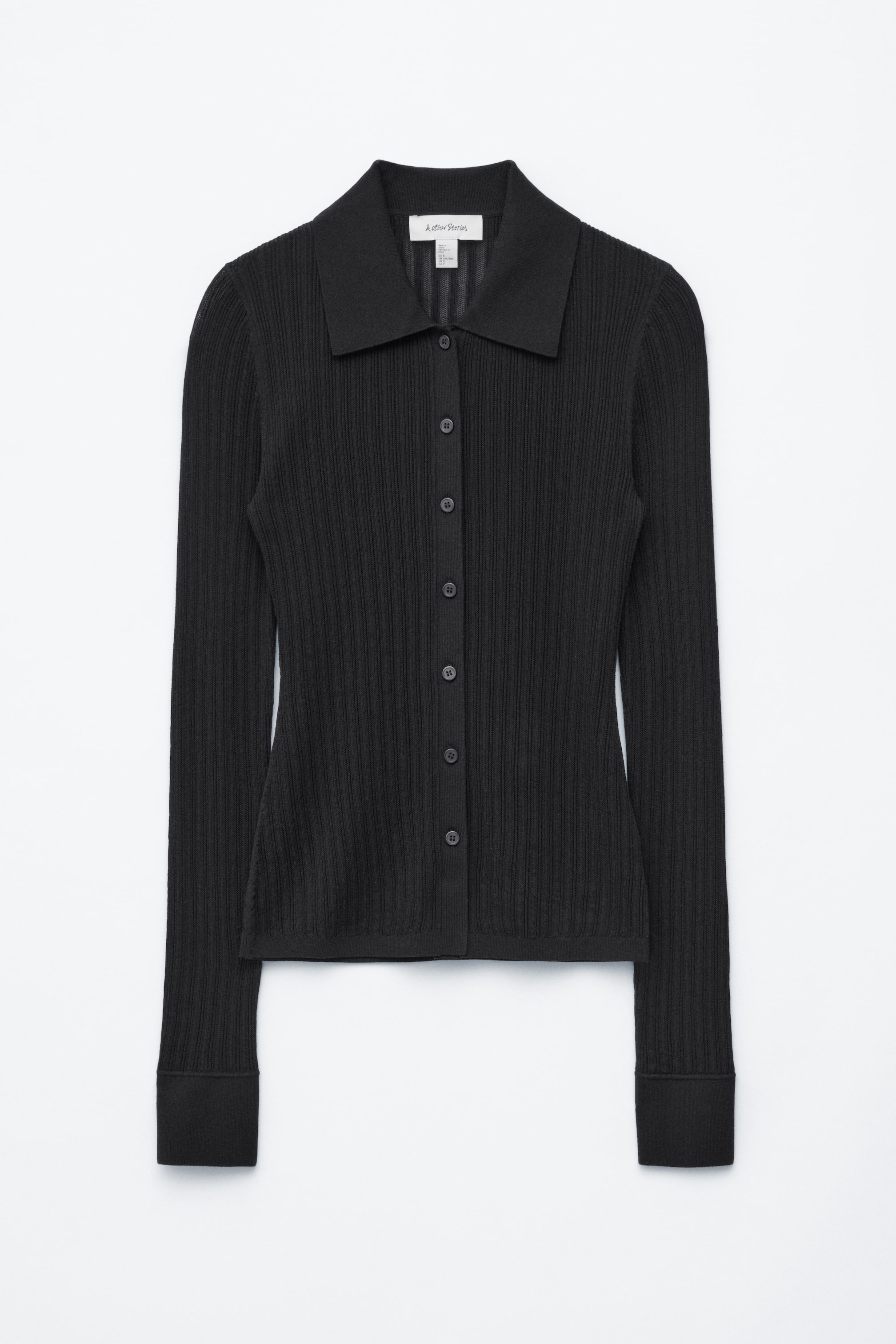 Ver imagen más grande: Un cárdigan de punto acanalado negro muestra su vista frontal. Presenta un cuello en punta, un cierre frontal completo con siete pequeños botones redondos y mangas largas acanaladas que terminan en puños acanalados.