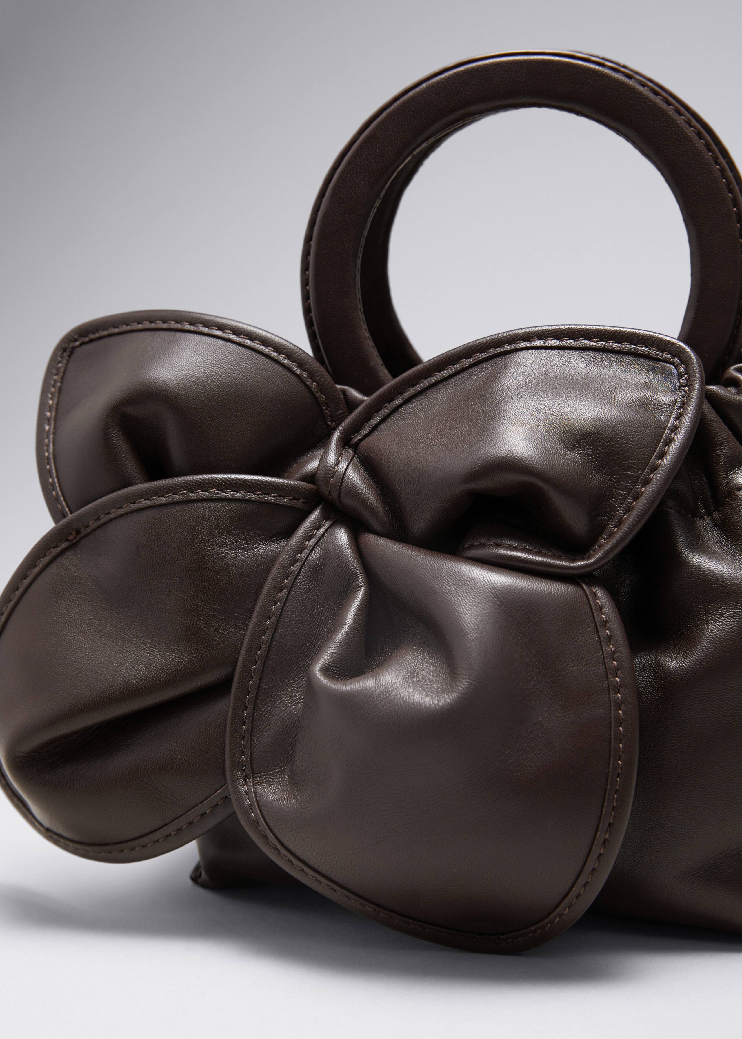 Borsa in pelle con fiore - {{variantName}} - Descrizione dettagliata