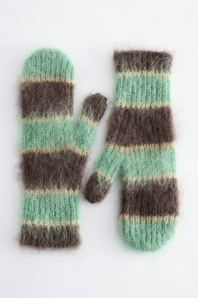 A pair of mohair-wool mittens is lying flat, showcasing a fuzzy, brushed texture with alternating horizontal stripes of mint green, dark brown, and thin beige. The front-facing mittens feature ribbed cuffs, with one mitten displaying its thumb pointing to the right and the other to the left. - 1