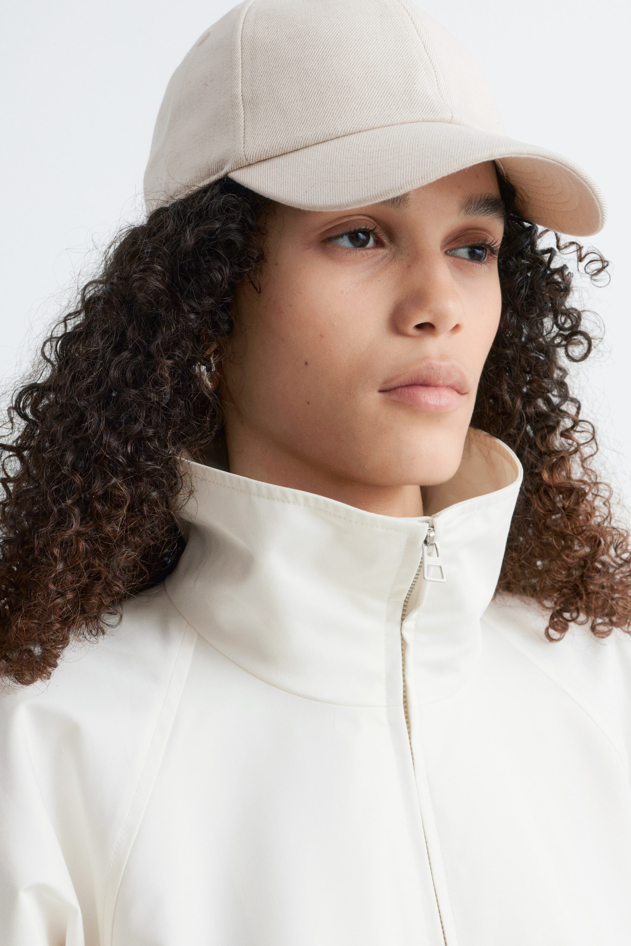 View larger image: A light beige cotton-linen baseball cap, featuring a structured crown and curved brim, is being worn by the model.