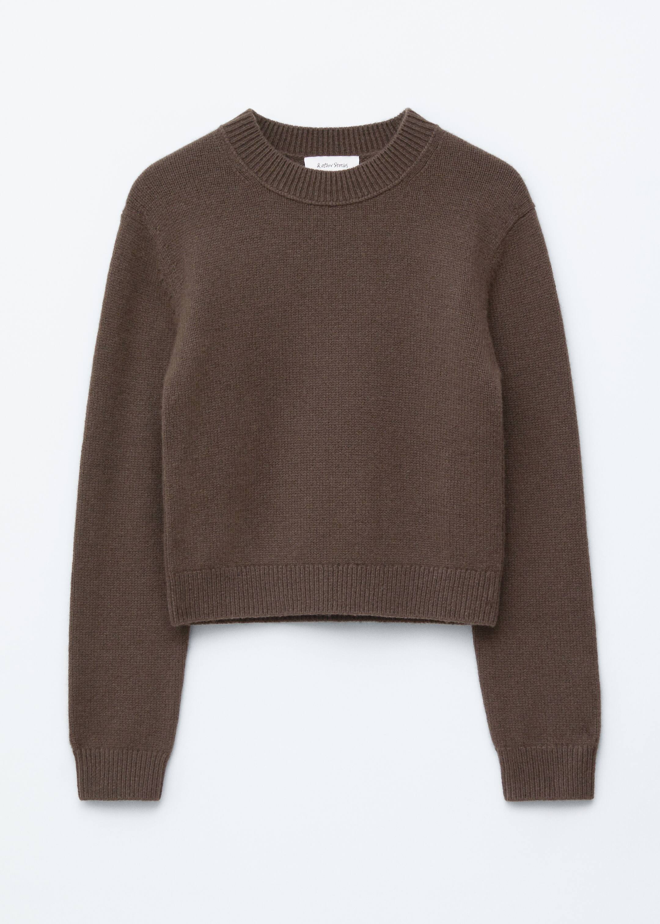 Agrandir l'image: Un pull court brun est présenté de face, avec une texture en maille simple, un col rond, des épaules légèrement tombantes, et des finitions côtelées sur le col, les poignets et l'ourlet.