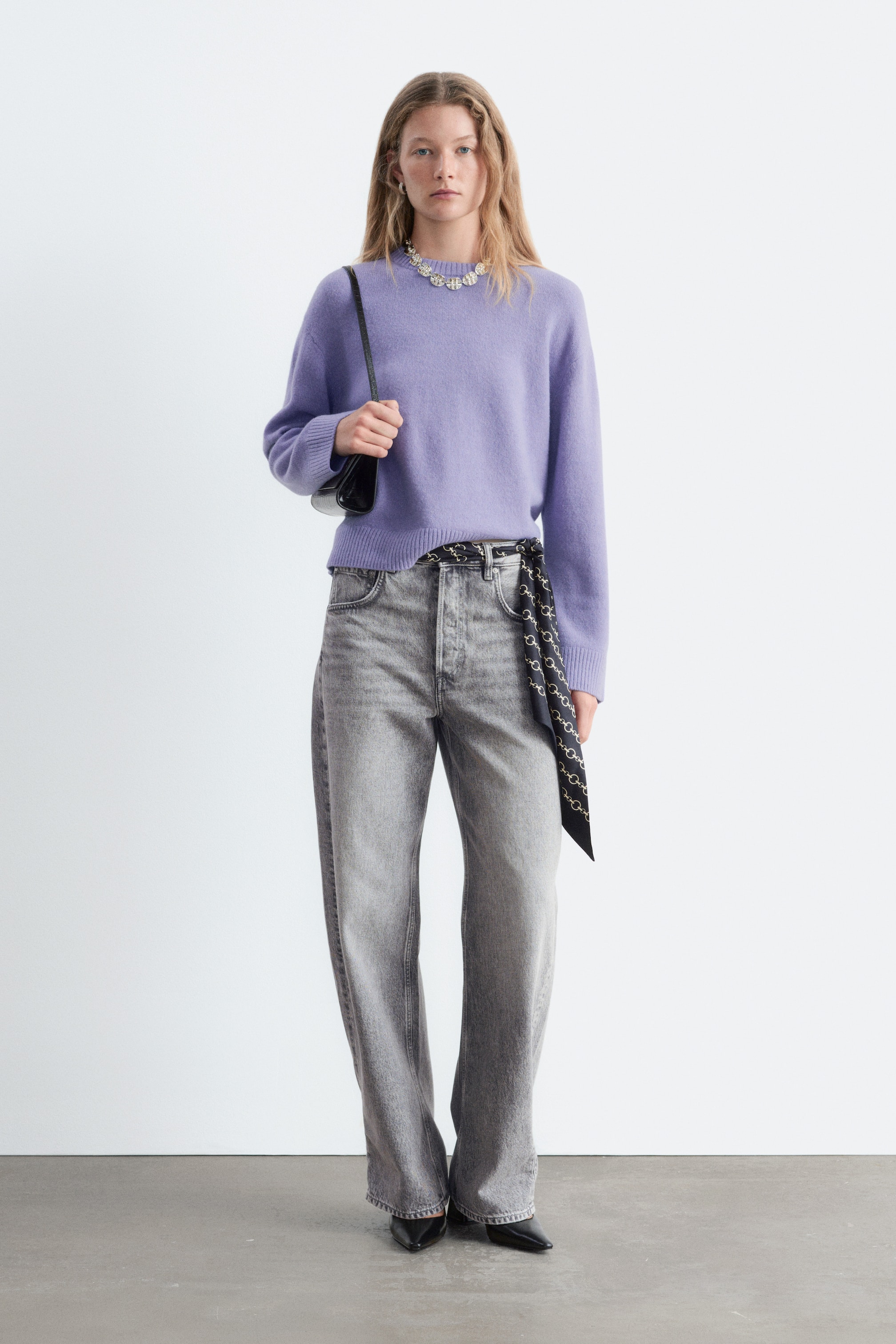 Visualizza l'immagine ingrandita: Il Boxy Knit Jumper, mostrato frontalmente in una tonalità lilla chiara, presenta una silhouette rilassata e squadrata con girocollo, maniche lunghe e dettagli a costine su colletto, polsini e orlo. La maglia dalla texture morbida cade morbida in vita, abbinata con un leggero rimbocco sopra jeans wide-leg per valorizzarne la vestibilità casual.