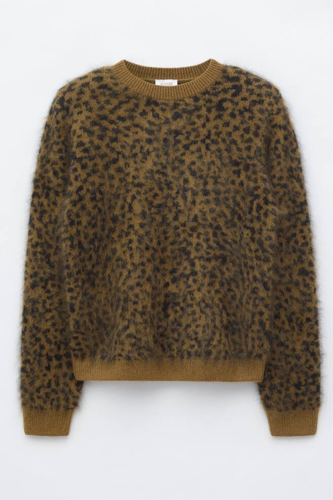 A long-sleeved, fuzzy knit jumper is displayed in a front-facing view, featuring an all-over leopard print in brown and black. The jumper has a ribbed crew neck, ribbed cuffs, and a ribbed hem. - 1