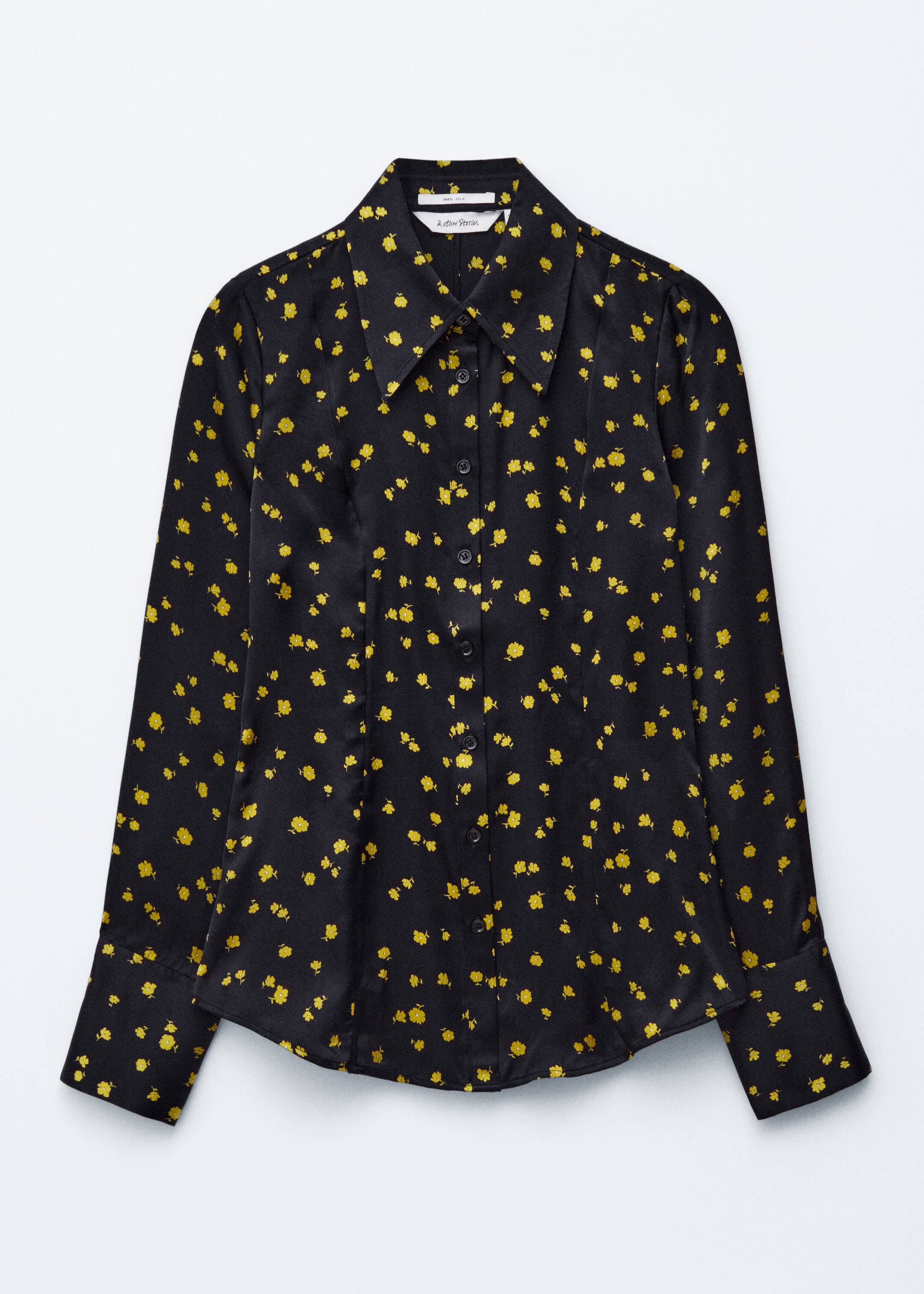 View larger image: A black long-sleeved shirt is lying flat, showcasing a scattered yellow floral pattern across its smooth fabric. It is featuring a point collar, a button-front placket with black buttons, wide button cuffs, and a curved hem.