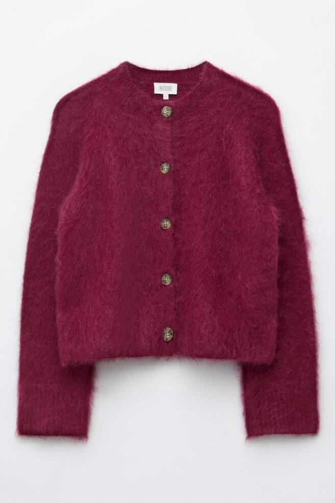 A berry-coloured mohair blend cardigan is facing front, showcasing a fuzzy, textured finish and a ribbed crew neck. The cardigan features a front button fastening with five marbled buttons, long sleeves with subtle ribbed cuffs, and a straight hem. - 1