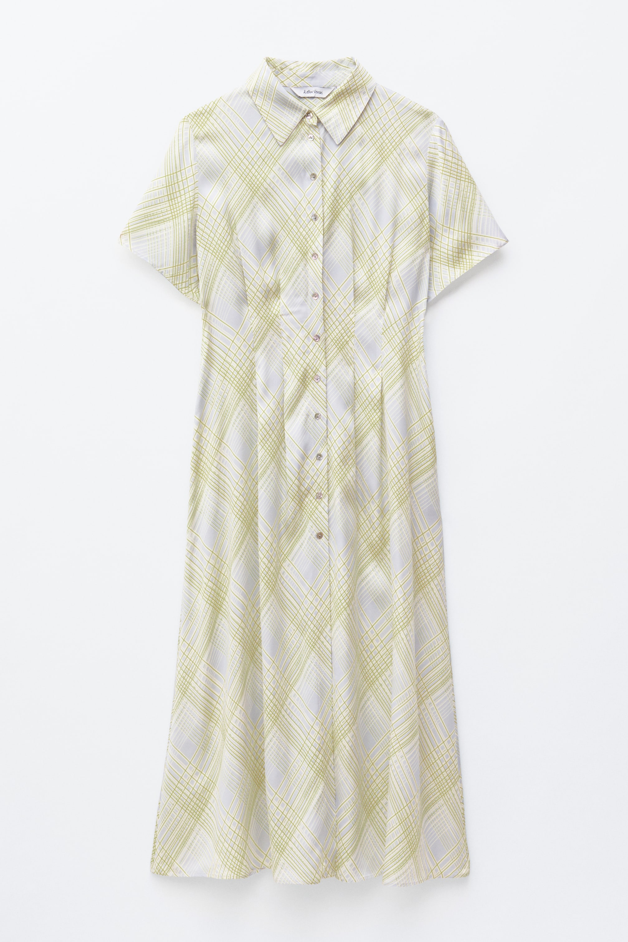Agrandir l'image: La robe chemise est présentée de face, arborant une couleur de fond claire avec un motif de grille vert lime en diagonale, un col classique, des manches courtes et une patte de boutonnage pleine longueur. La robe est cintrée à la taille avec des pinces, créant de doux plis qui descendent jusqu'à son ourlet longueur cheville.