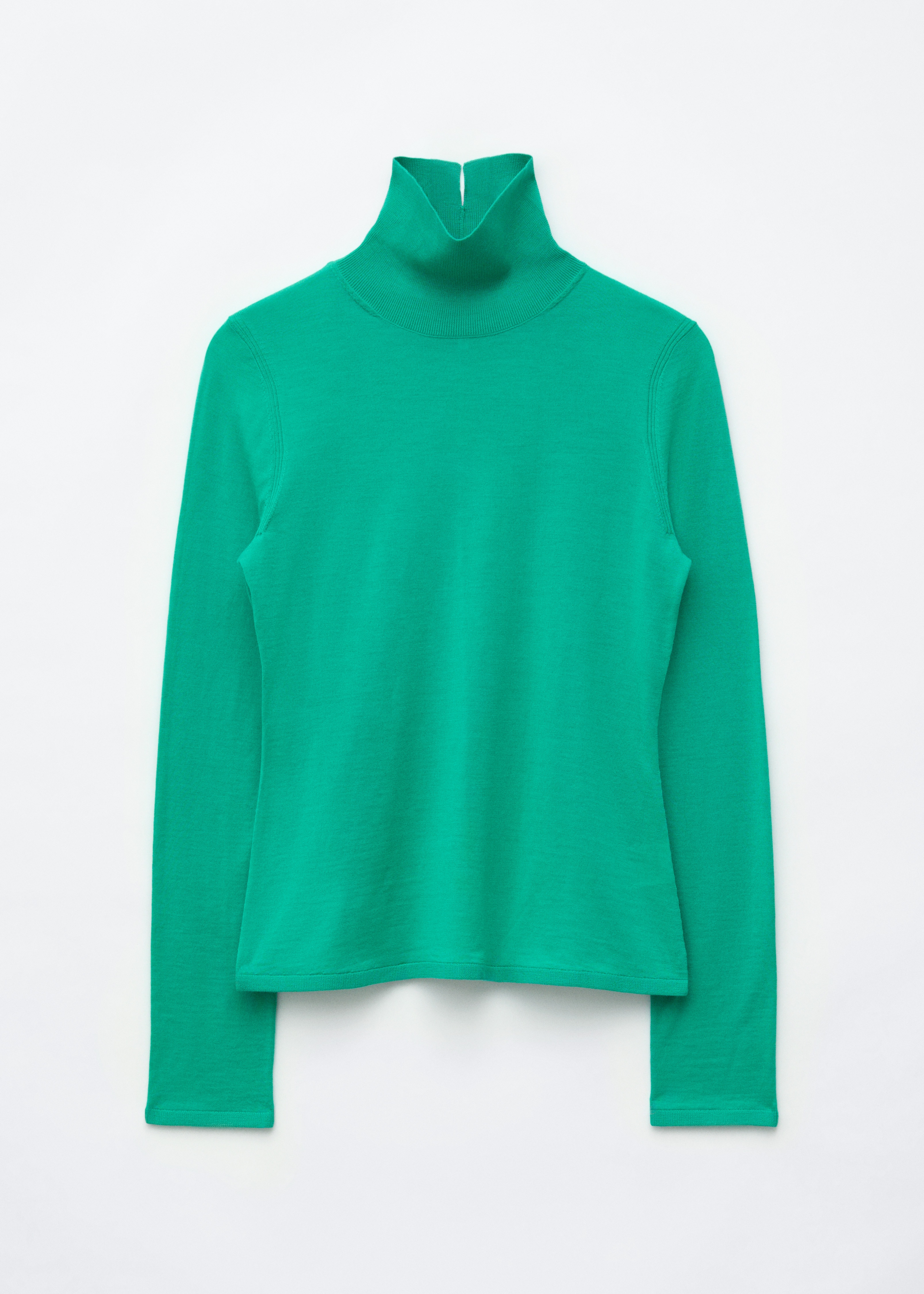 A modell egy zÃ¶ld merinÃ³gyapjÃº garbÃ³s felsÅt visel, magas, visszahajtott nyakkal Ã©s hosszÃº ujjakkal. A slim fit felsÅ egy szÃ©les Ã¶vvel ellÃ¡tott szÃ¼rke kockÃ¡s szoknyÃ¡ba van betÅ±rve, mikÃ¶zben a modell az egyik karja alatt egy fekete bÅr clutch tÃ¡skÃ¡t tart.