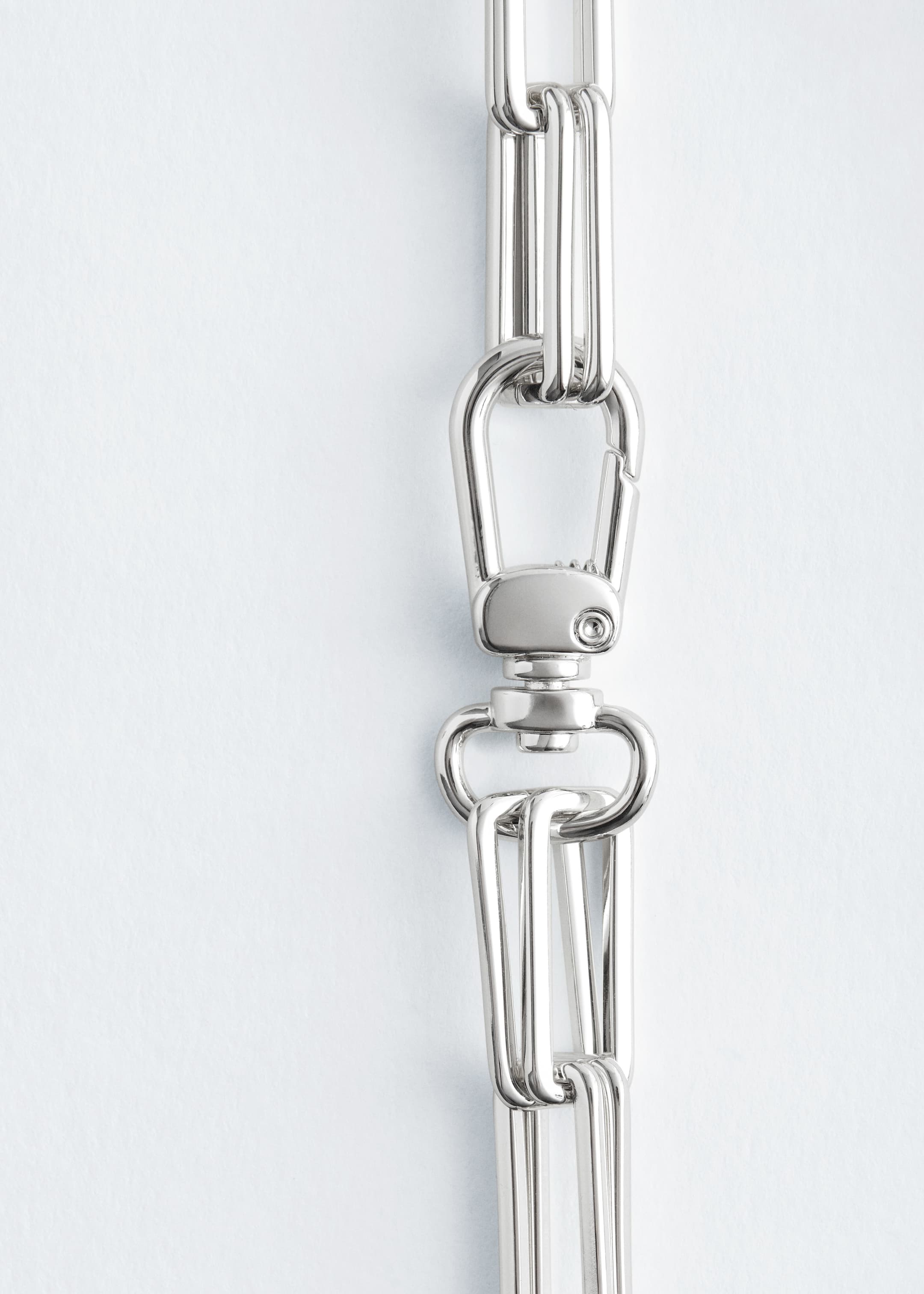 Agrandir l'image: Un collier à maillons épais de couleur argentée présente des maillons rectangulaires allongés, chacun formé de trois barres parallèles. Un grand fermoir pivotant est visible, reliant deux segments de la chaîne.