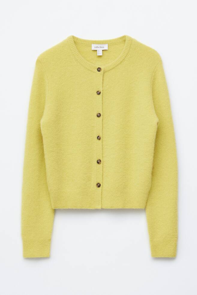 A cosy, yellow cardigan is showcased from the front, featuring a round neckline, a full button-front fastening with six round brown buttons, and ribbed cuffs and hem. - 1