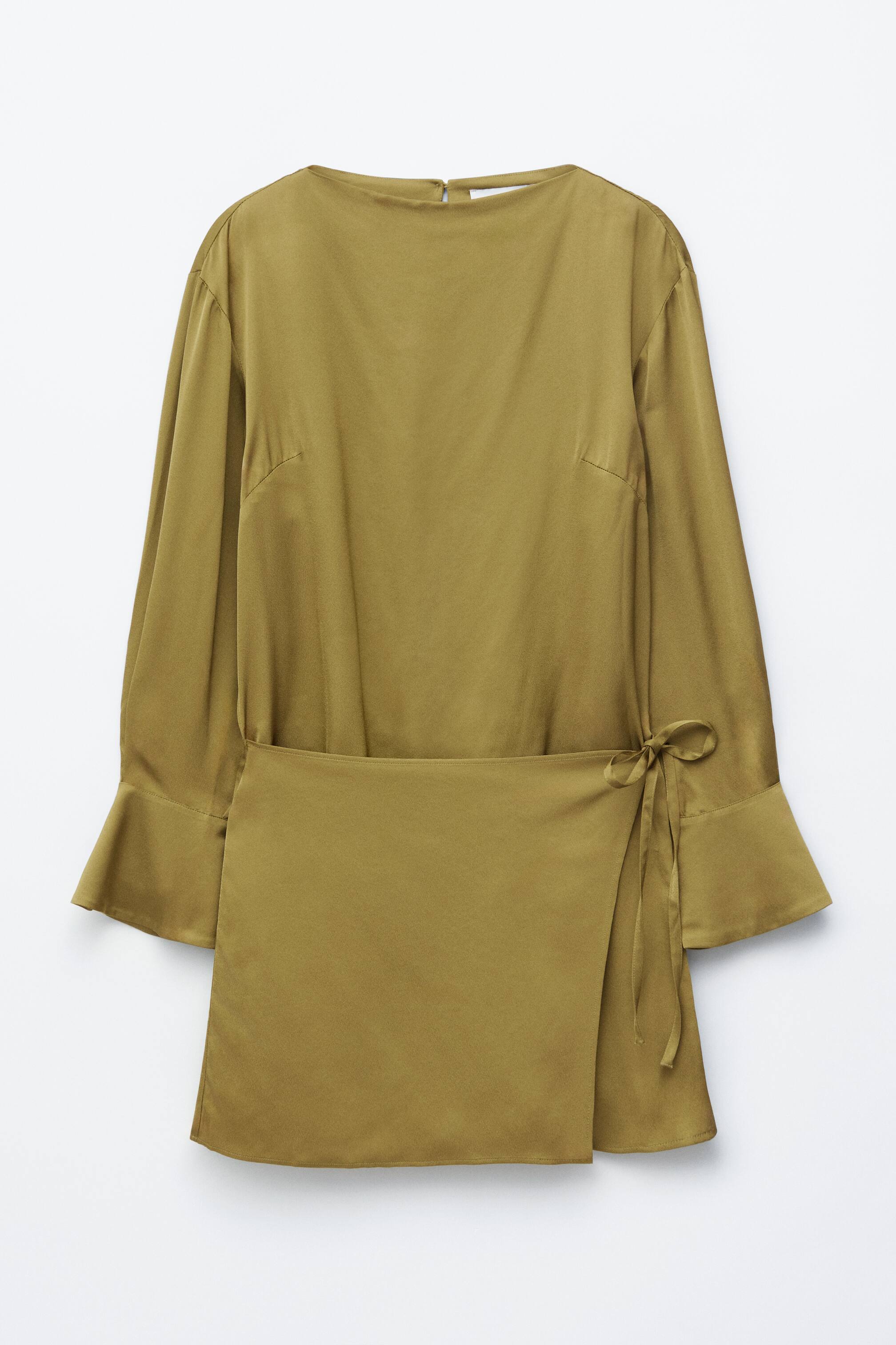 Преглед на по-голямо изображение: Изглед отпред на маслиненозелена рокля, която подчертава лодковото деколте, дългите, свободни ръкави с широки маншети и малък цип на гърба на врата. Роклята е с долна част в стил "обвивка", която се завързва с панделка от дясната страна и е изработена от гладка, сатенена материя.
