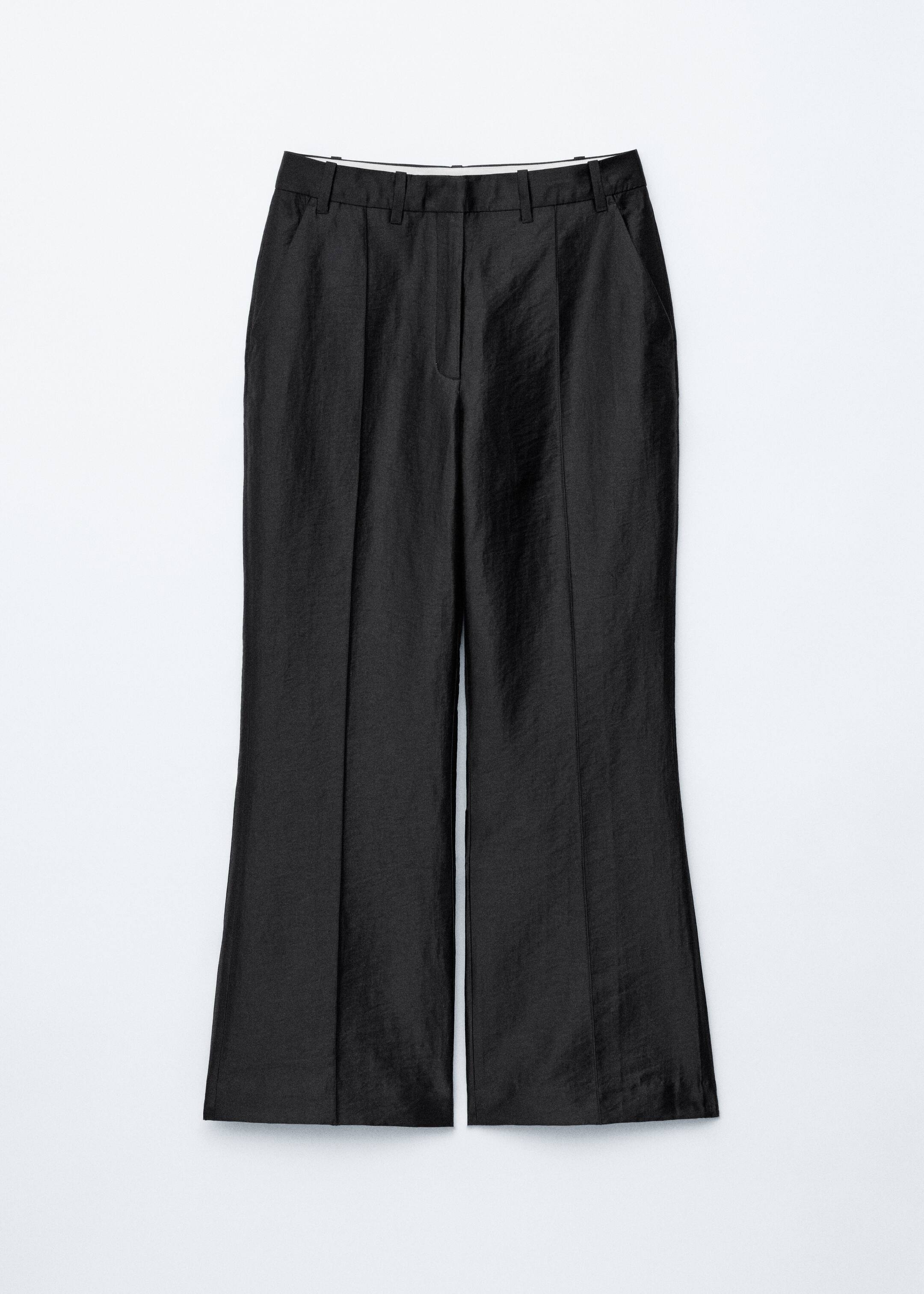 Größeres Bild anzeigen: Schwarze, weit geschnittene Hosen werden von vorne gezeigt, mit einer subtilen, geknitterten Textur, einem sichtbaren Reißverschluss und zwei markanten Falten, die sich über jedes Bein erstrecken.