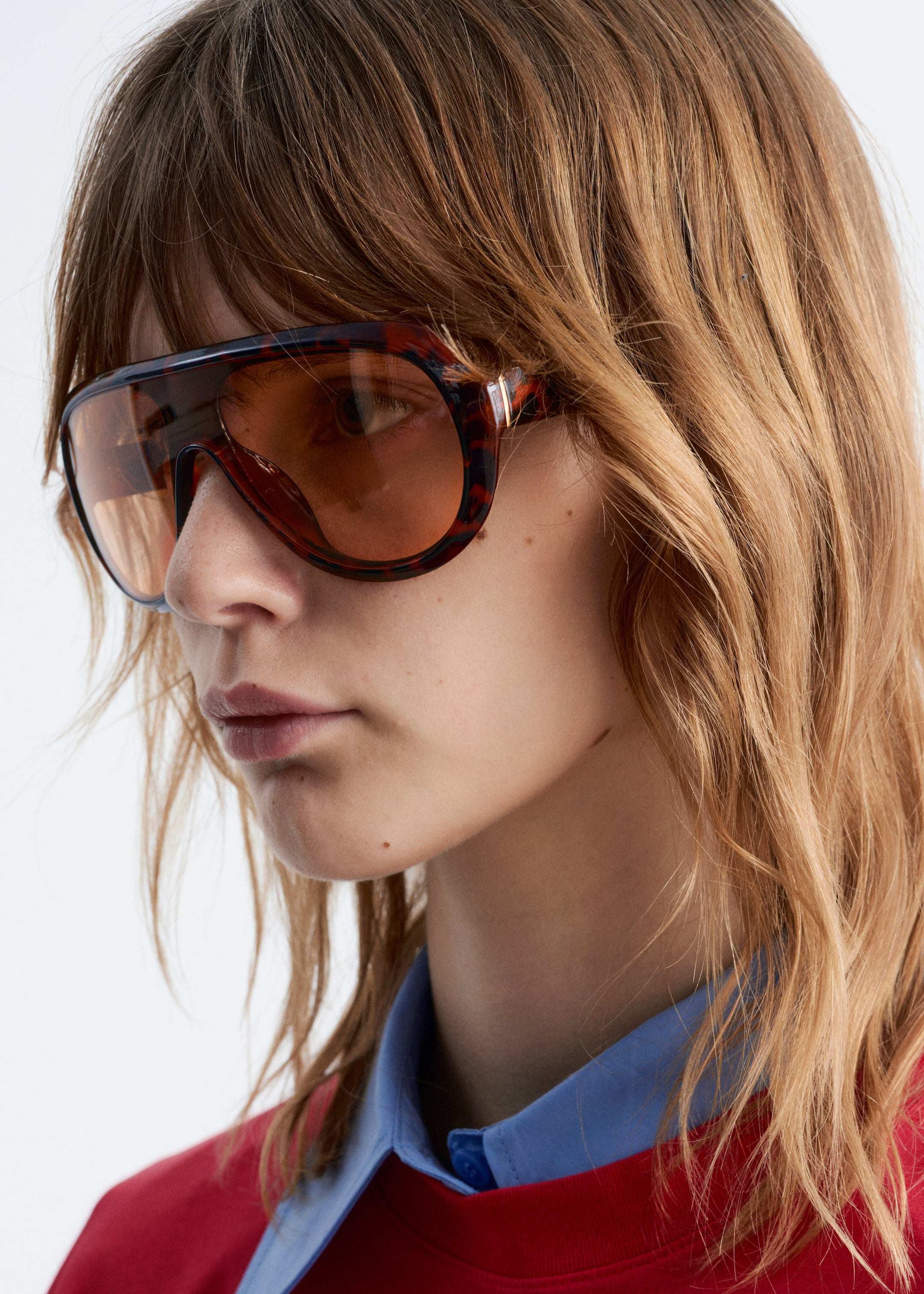 Se større billede: Tortoiseshell aviator-solbriller bæres, og de vender en smule til venstre. De har store, omsluttende stel med brune tonede linser og en lille guldfarvet detalje på stangen.