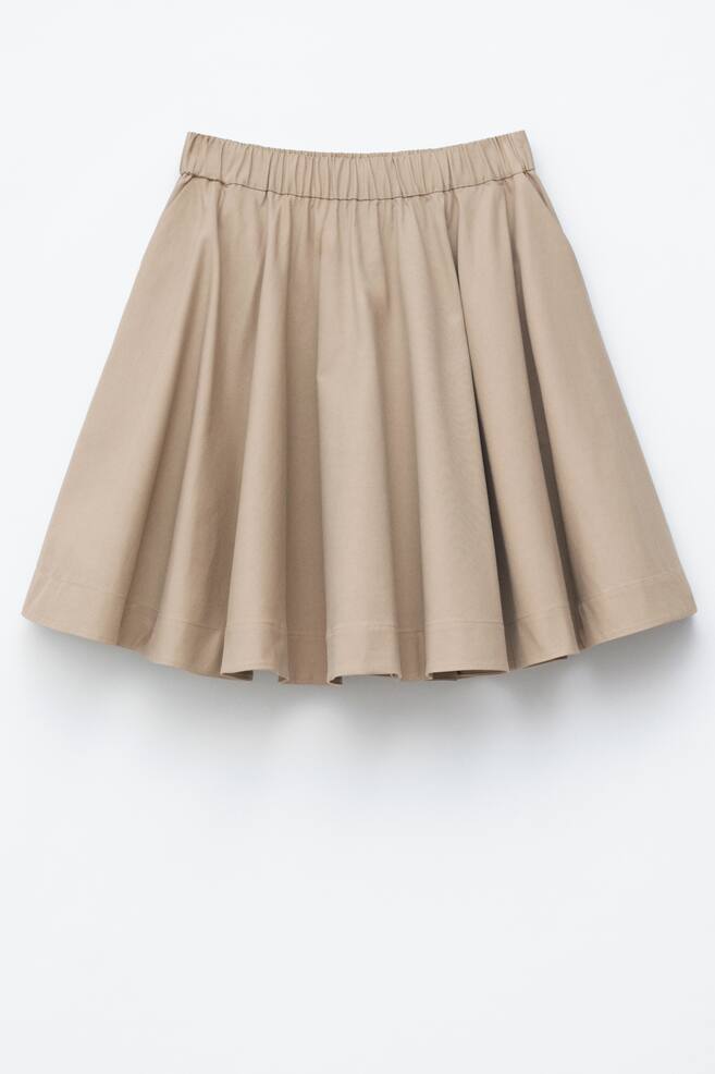 A tan flared skirt is displayed from the FRONT, featuring an elasticated waistband with gathers and soft folds that create volume. - 1