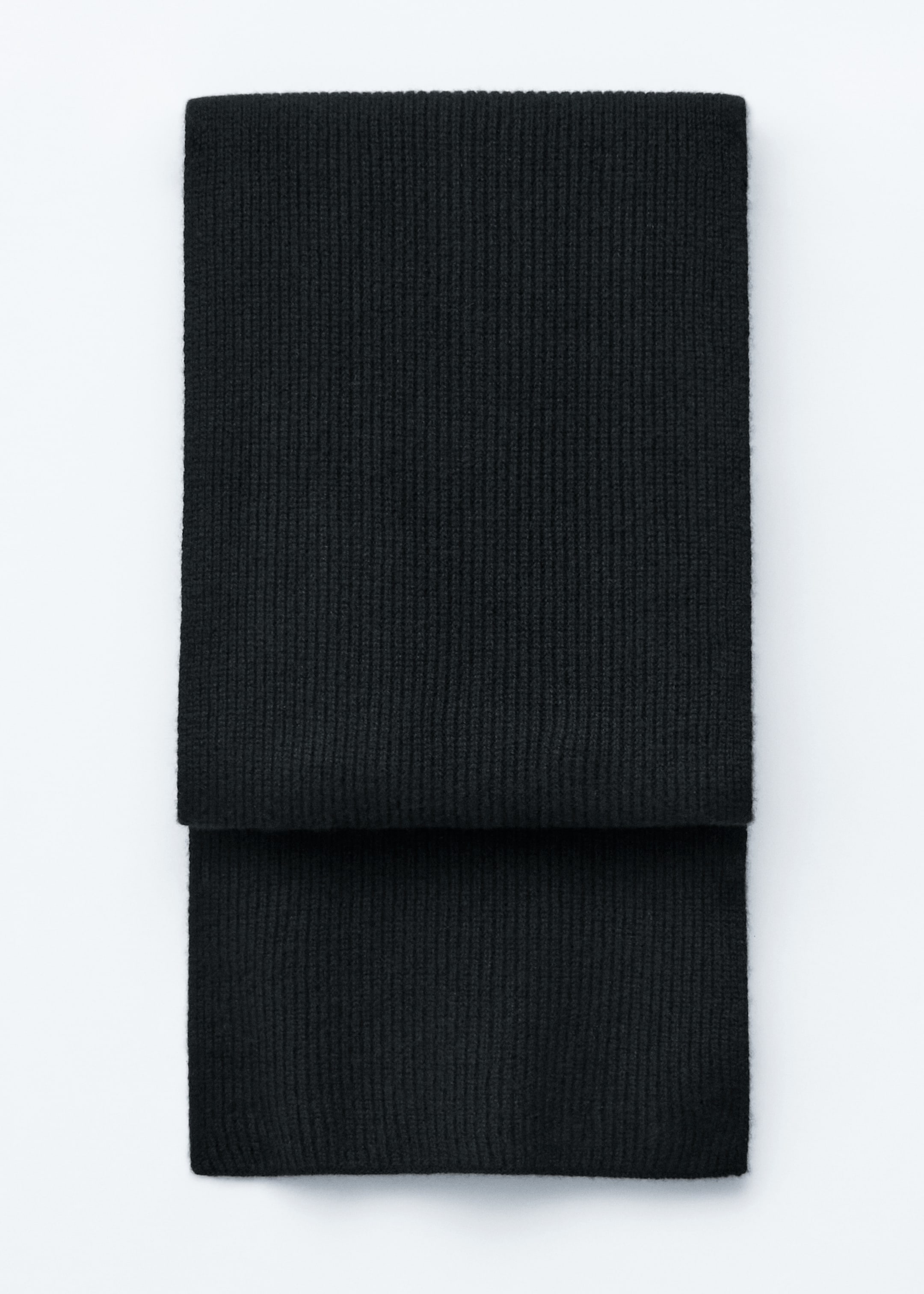 Visualizza immagine più grande: Una sciarpa nera in morbido cashmere è distesa piatta, presentata da una vista frontale. Presenta una texture a coste prominente ed è piegata orizzontalmente a metà.