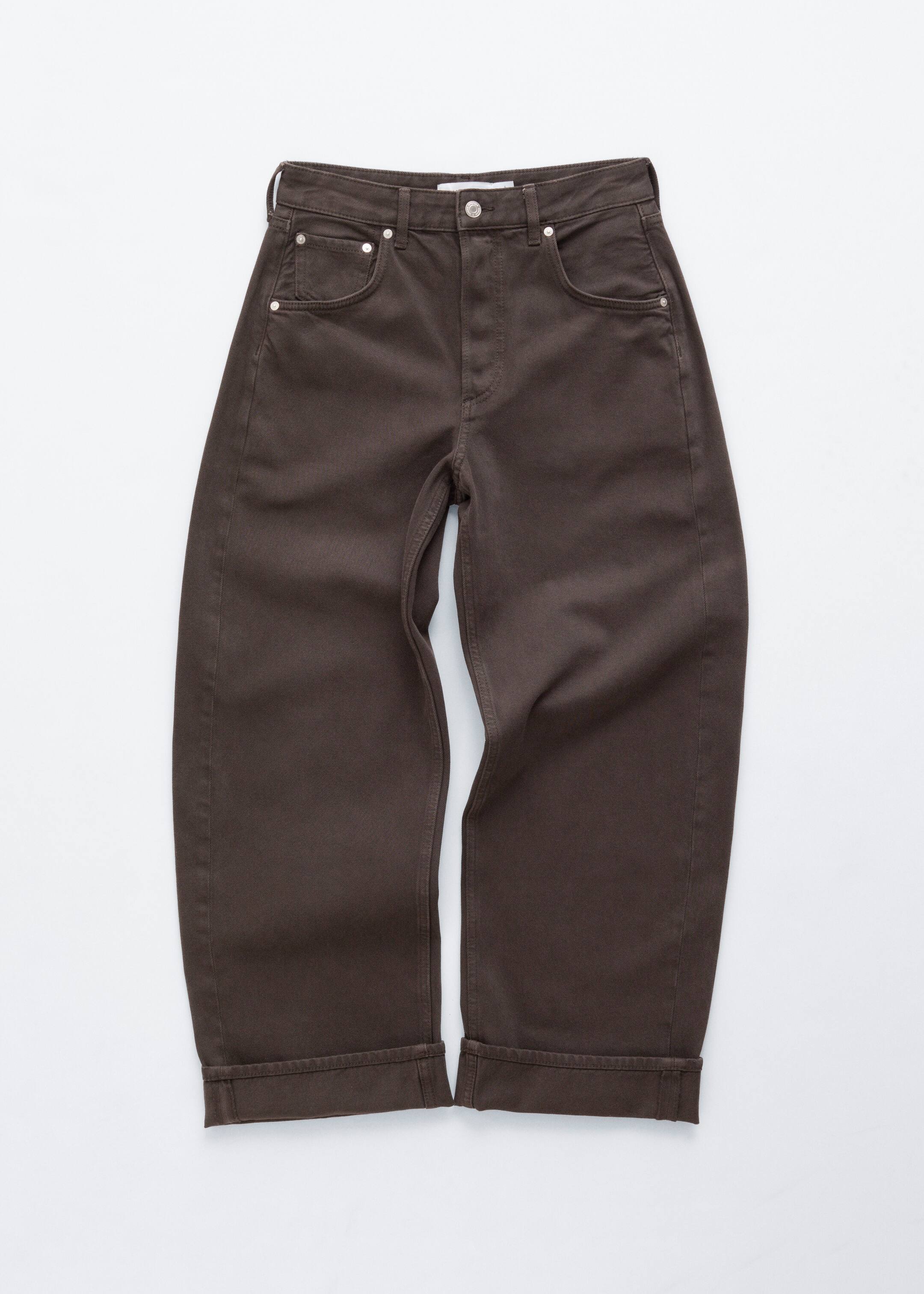 Grotere afbeelding bekijken: Bruine jeans worden frontaal getoond, met een klassiek 5-pocket design en een zichtbare knoopsluiting. Ze hebben een barrelvormige pijp en een ingenaaid omslag aan de zoom.