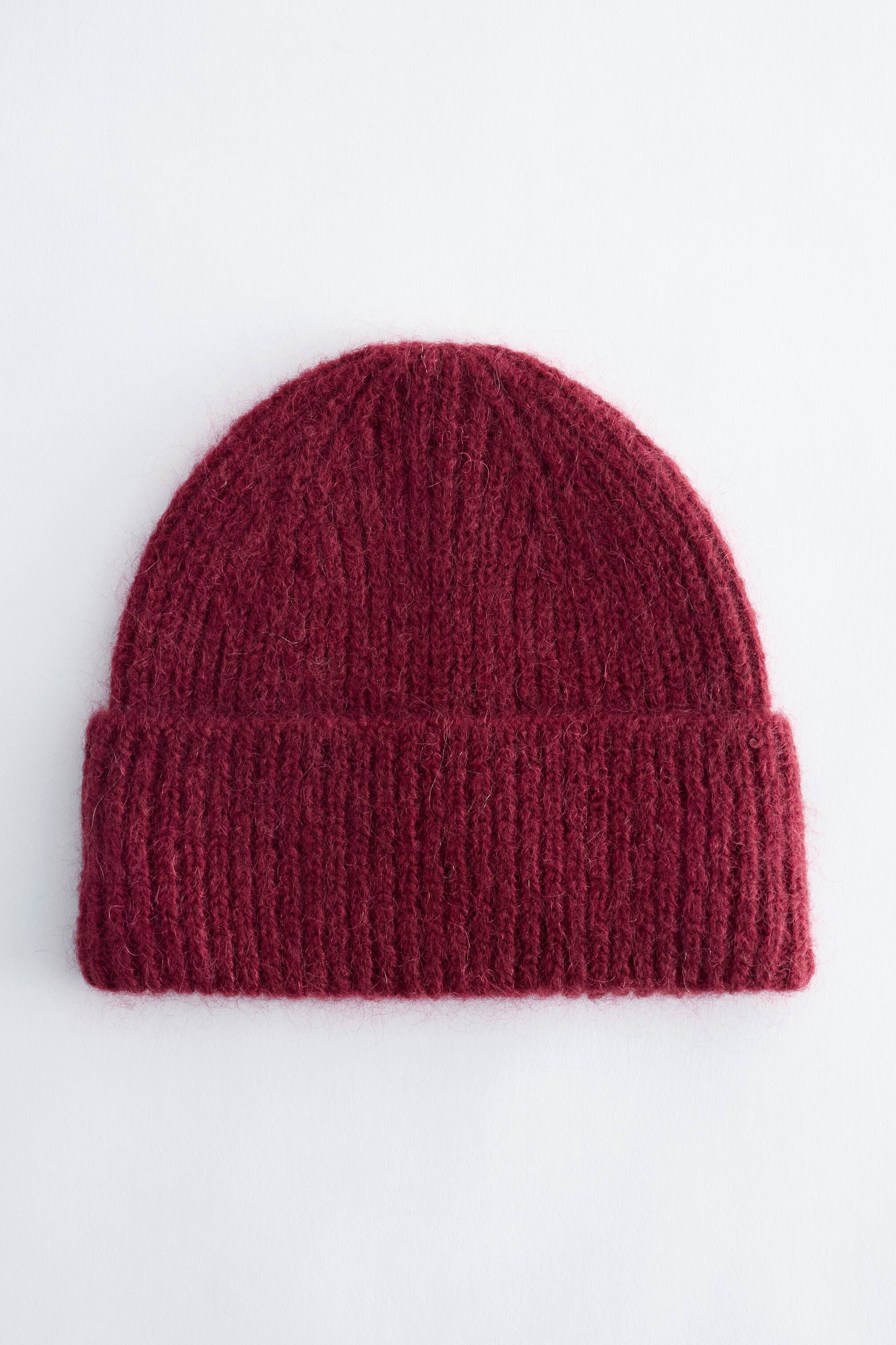 Vezi imaginea mai mare: O căciulă beanie din tricot rib, de culoare bordo, este prezentată din față, având o textură pufoasă din amestec de mohair și o margine lată răsfrântă.