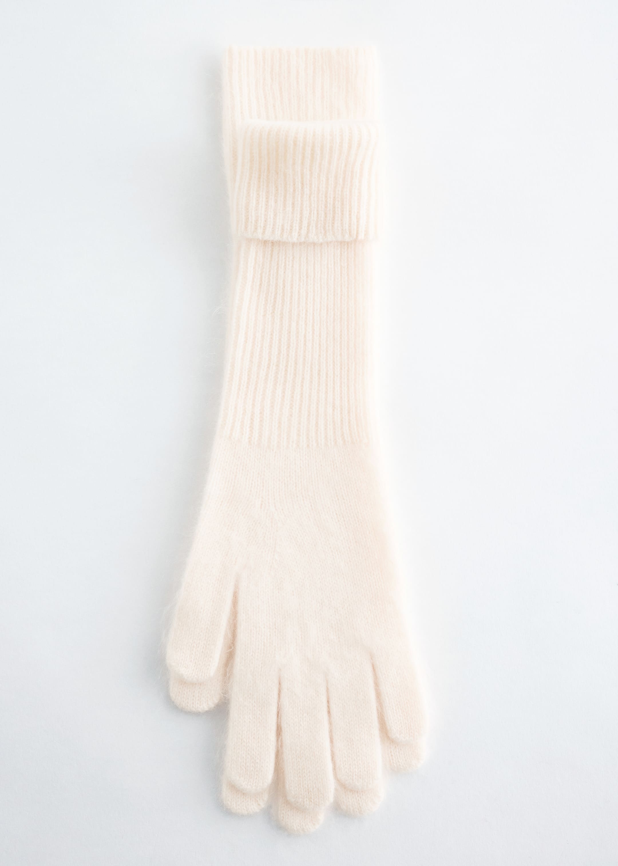 View larger image: A single cream-colored knitted brushed cashmere glove is lying flat, presenting its front. It is featuring a fine knit body with a visible fuzzy texture and a wide, ribbed cuff that is folded over.