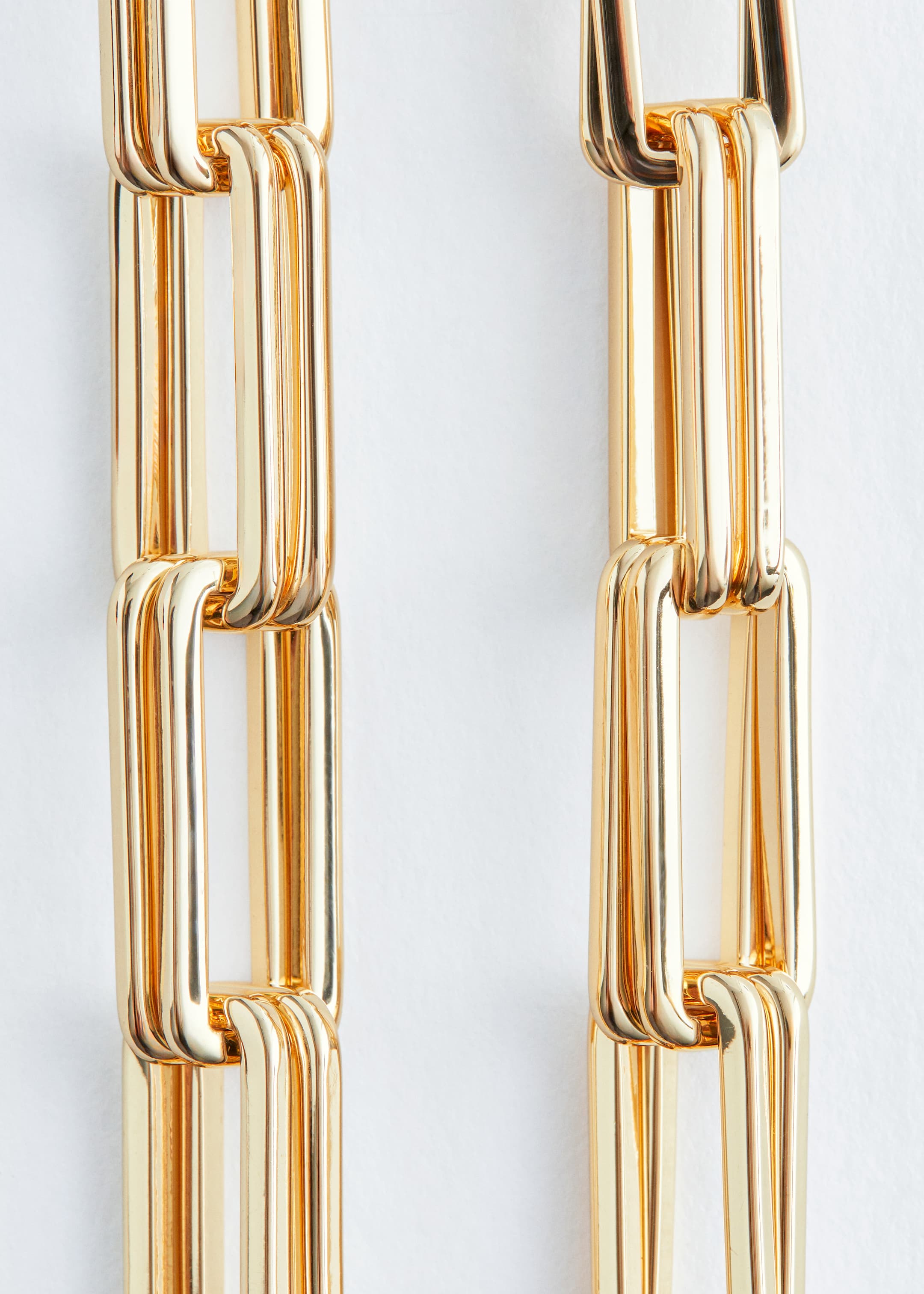 Ver imagen más grande: Un collar de eslabones gruesos con tono dorado se muestra en un primer plano. Sus eslabones rectangulares presentan una superficie pulida y reflectante y están entrelazados verticalmente.