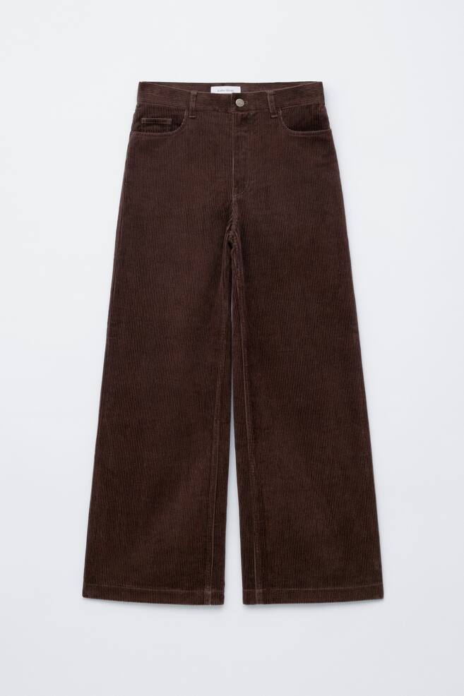 A pair of dark brown corduroy wide-leg pants is being displayed from the front. The pants are featuring a button closure, belt loops, and front slant pockets with a small coin pocket. - 1