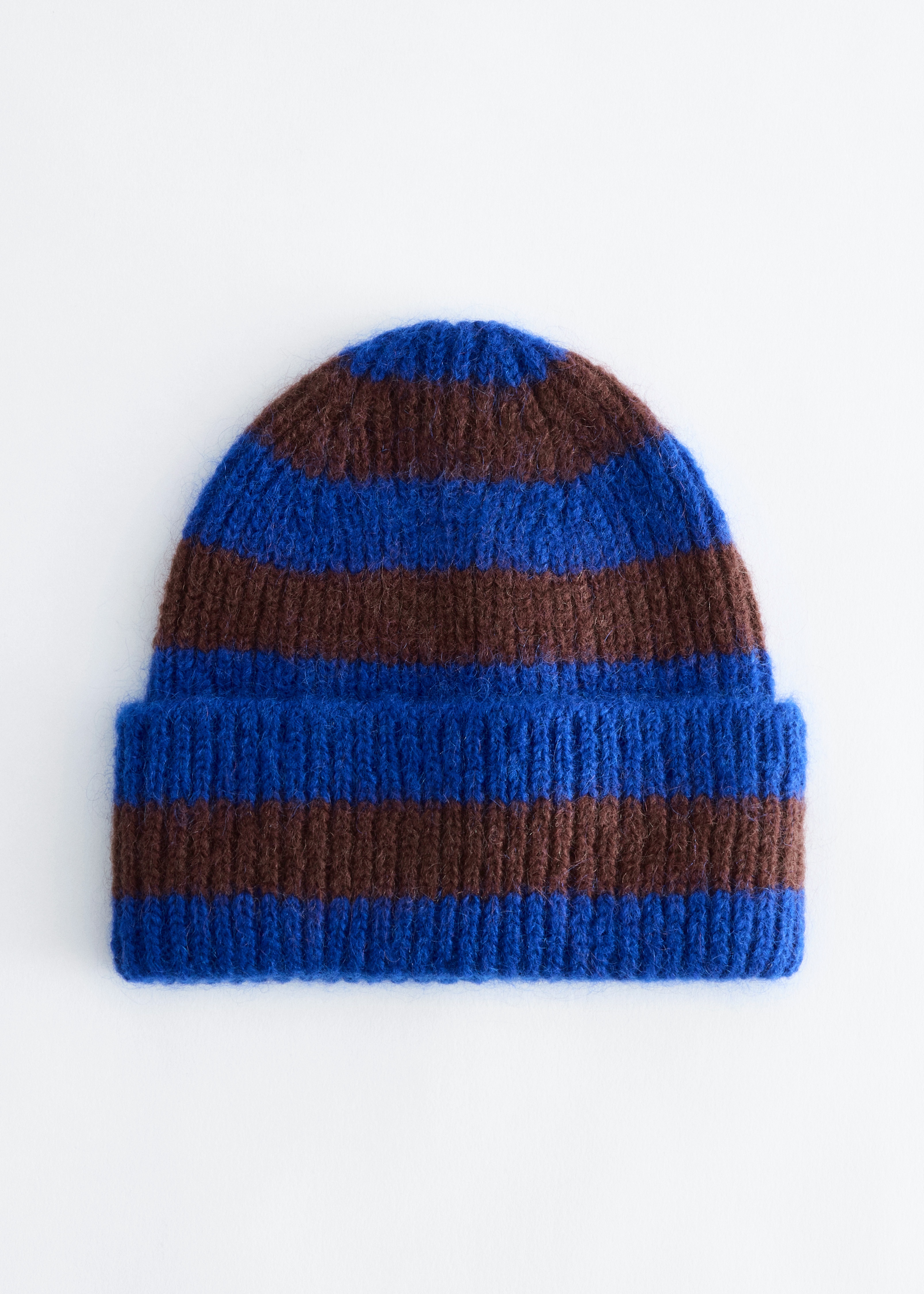 EtuapÃ¤in kuvattu ribbiresorinen pipo, jossa on vaakasuorat kuninkaansinisen ja tummanruskean sÃ¤vyn raidat. Pipo on muotoiltu taitetulla leveÃ¤llÃ¤ reunuksella, joka korostaa sen pehmeÃ¤Ã¤ ja pÃ¶rrÃ¶istÃ¤ tekstuuria.