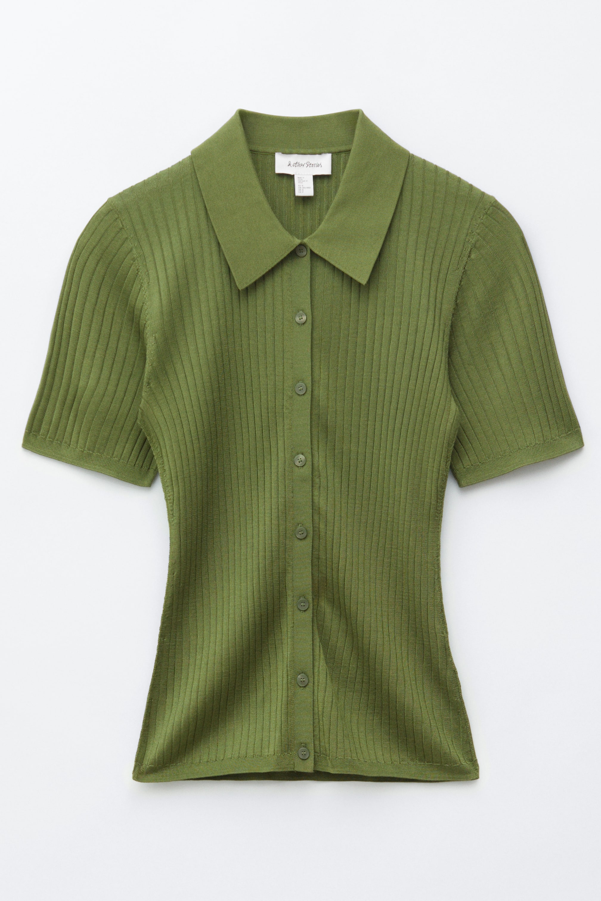 הצגת תמונה גדולה יותר: חולצה סרוגה בצלעות. חולצה ירוקה זית זו כוללת צווארון מחודד, שרוולים קצרים ומפתח כפתורים מלא עם כפתורים תואמים. היא מציגה צלעות אנכיות בולטות לאורך העיצוב הצמוד שלה.