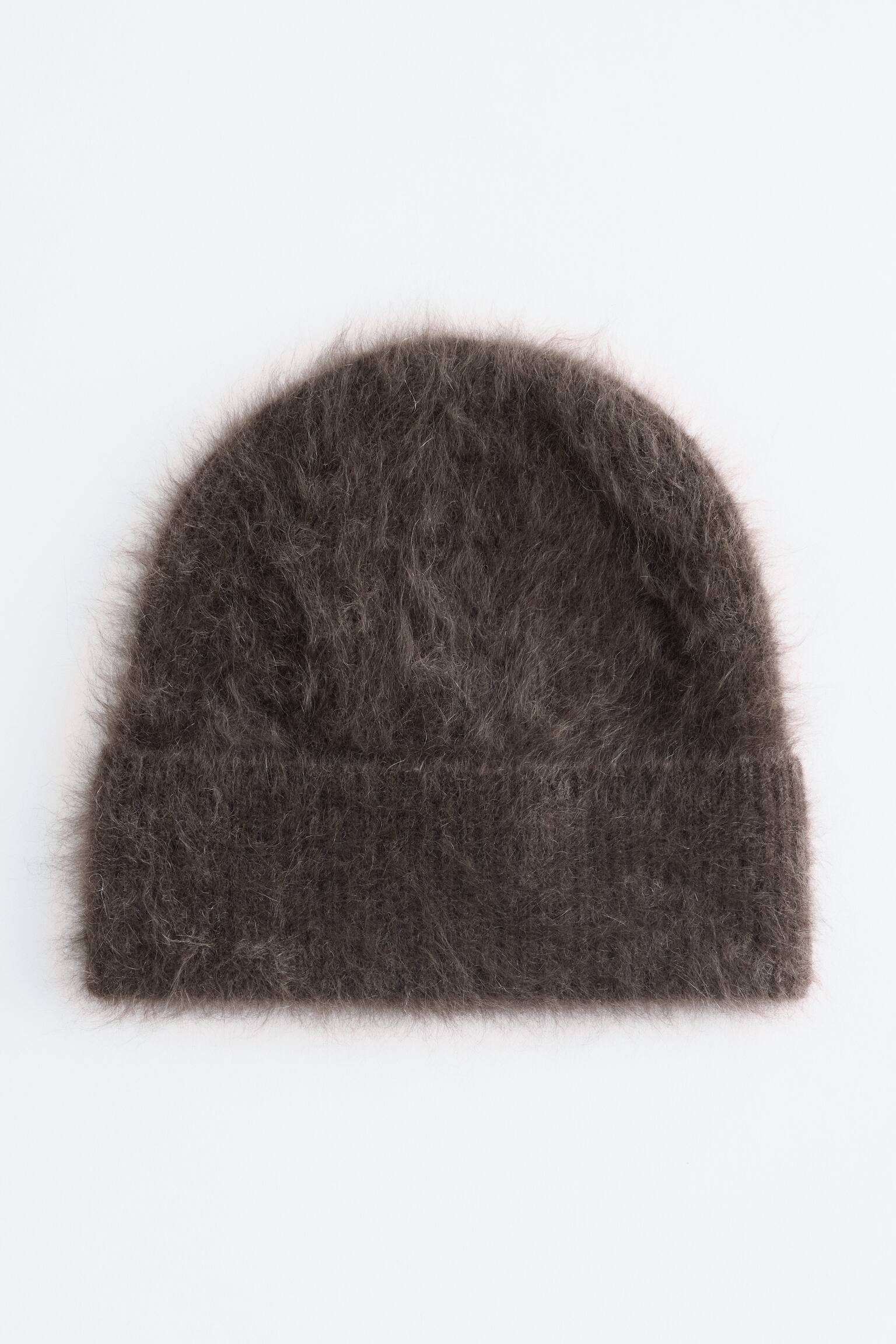 Un gorro de punto borreguito de color marrÃ³n oscuro muestra una superficie muy texturizada y de aspecto peludo, con un amplio puÃ±o vuelto y una copa redondeada, visto de frente.