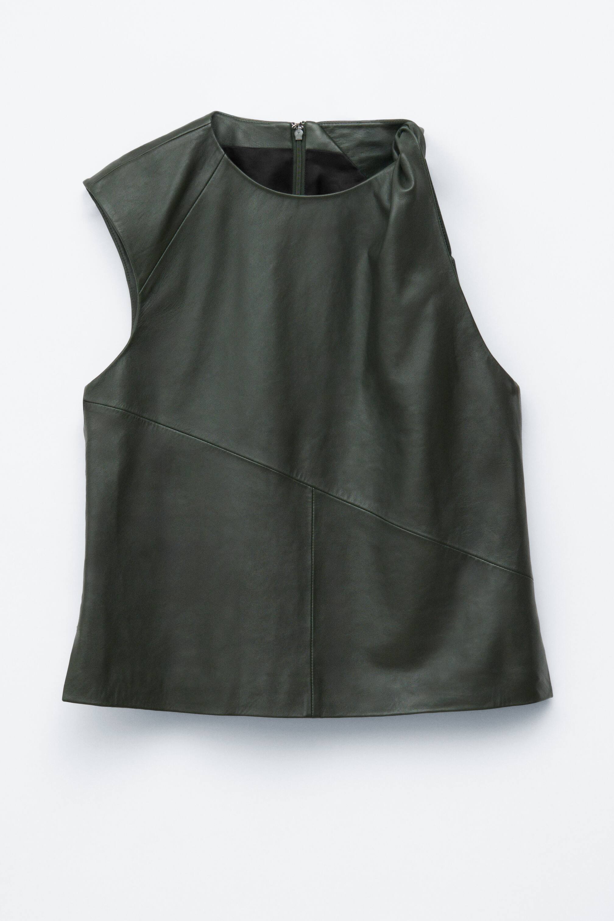 Visualizza immagine più grande: Un top senza maniche effetto pelle di colore verde oliva scuro è mostrato FRONTE, caratterizzato da uno scollo rotondo con una zip posteriore visibile, un design asimmetrico con una manica a cappuccio sulla sinistra e una spalla destra arricciata, e cuciture diagonali che attraversano il fronte.