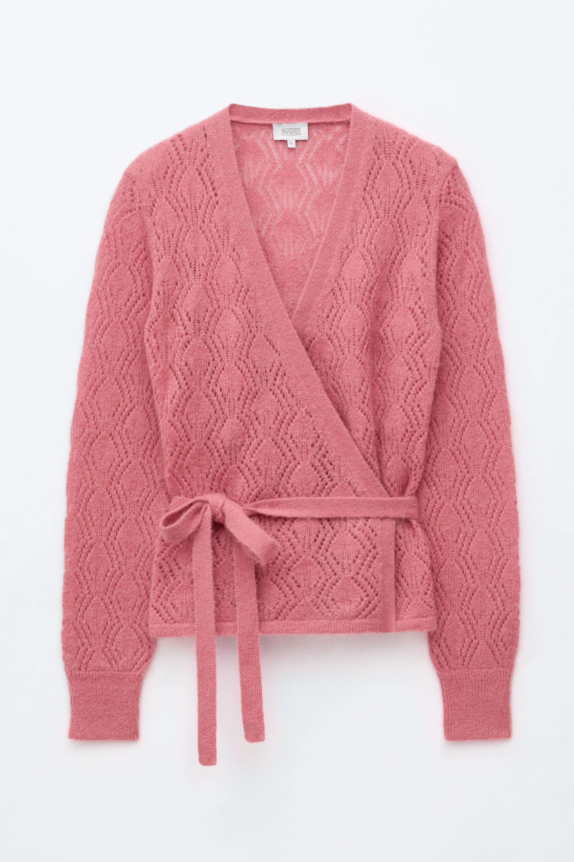 View larger image: The pink wrap cardigan is shown from the front, featuring a diamond-shaped openwork knit pattern throughout. It is designed with a V-neckline, long sleeves with ribbed cuffs, and a self-tie belt tied in a bow at the waist.