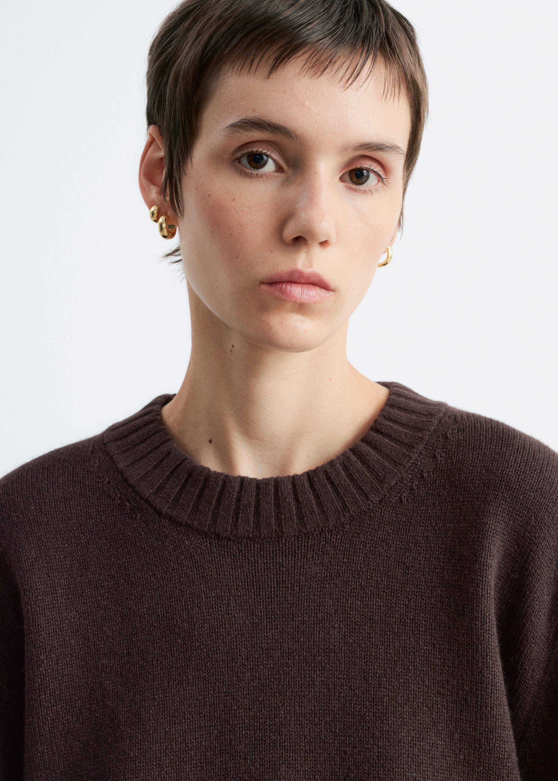 Agrandir l'image: Un pull marron foncé avec un col rond côtelé est porté par le mannequin.