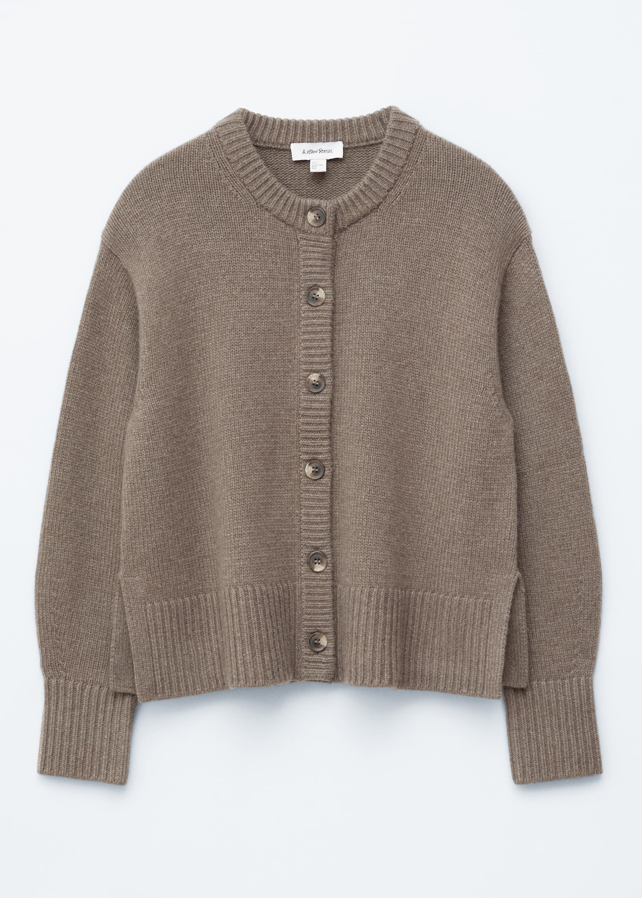 Visualizza immagine più grande: Un cardigan marrone a maglia viene mostrato dalla parte anteriore, caratterizzato da un girocollo a coste e una chiusura frontale con sette bottoni rotondi marroni visibili. Ha anche maniche lunghe con polsini a coste e un orlo a coste con sottili spacchi laterali.