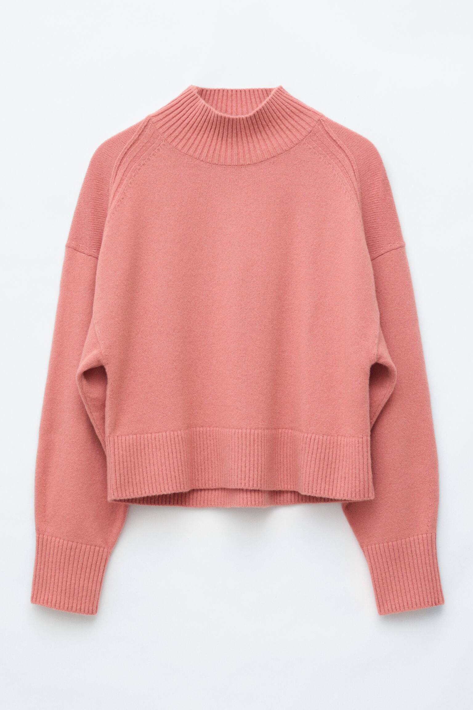 Un pull col montant rose est prÃ©sentÃ© de face, avec un col montant cÃ´telÃ©, des Ã©paules tombantes avec coutures orientÃ©es vers l'avant, ainsi que de larges finitions cÃ´telÃ©es aux poignets et Ã  l'ourlet. - 1