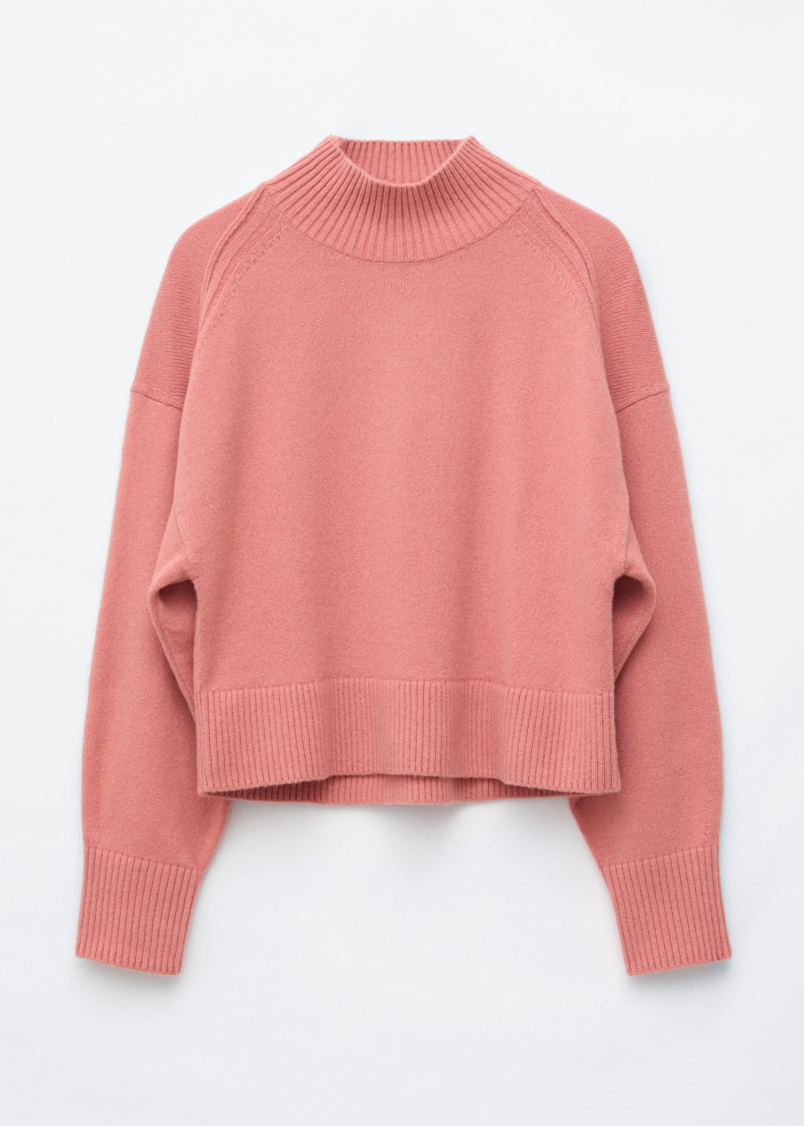 A pink mock turtleneck sweater is shown from the front, featuring a ribbed mock turtleneck, dropped shoulders with forward-facing seams, and wide ribbed trim at the cuffs and hem.