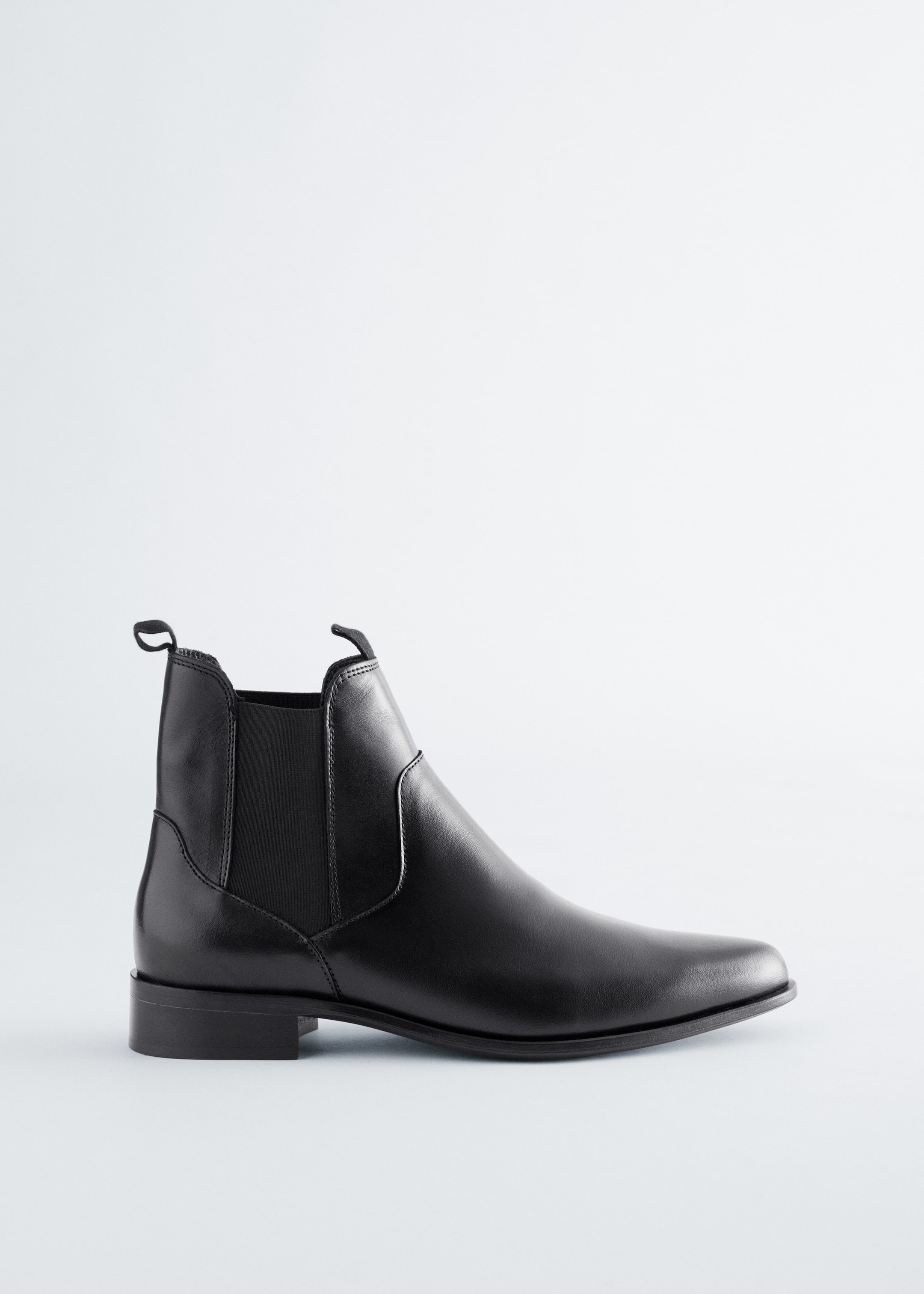 Grotere afbeelding bekijken: Een zwarte leren Chelsea-boot met elastische zijpanelen, een treklus aan de achterkant, een puntige neus en een lage blokhak.