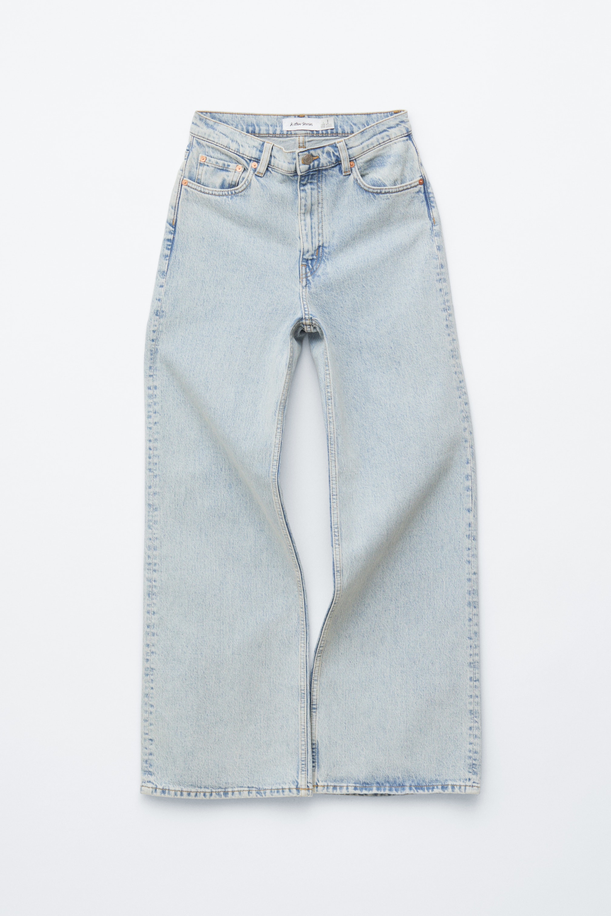 Agrandir l'image: Les jeans en denim délavé clair se présentent de face, avec une taille haute, des jambes larges et un design classique à 5 poches, avec une fermeture éclair visible et une braguette à bouton.